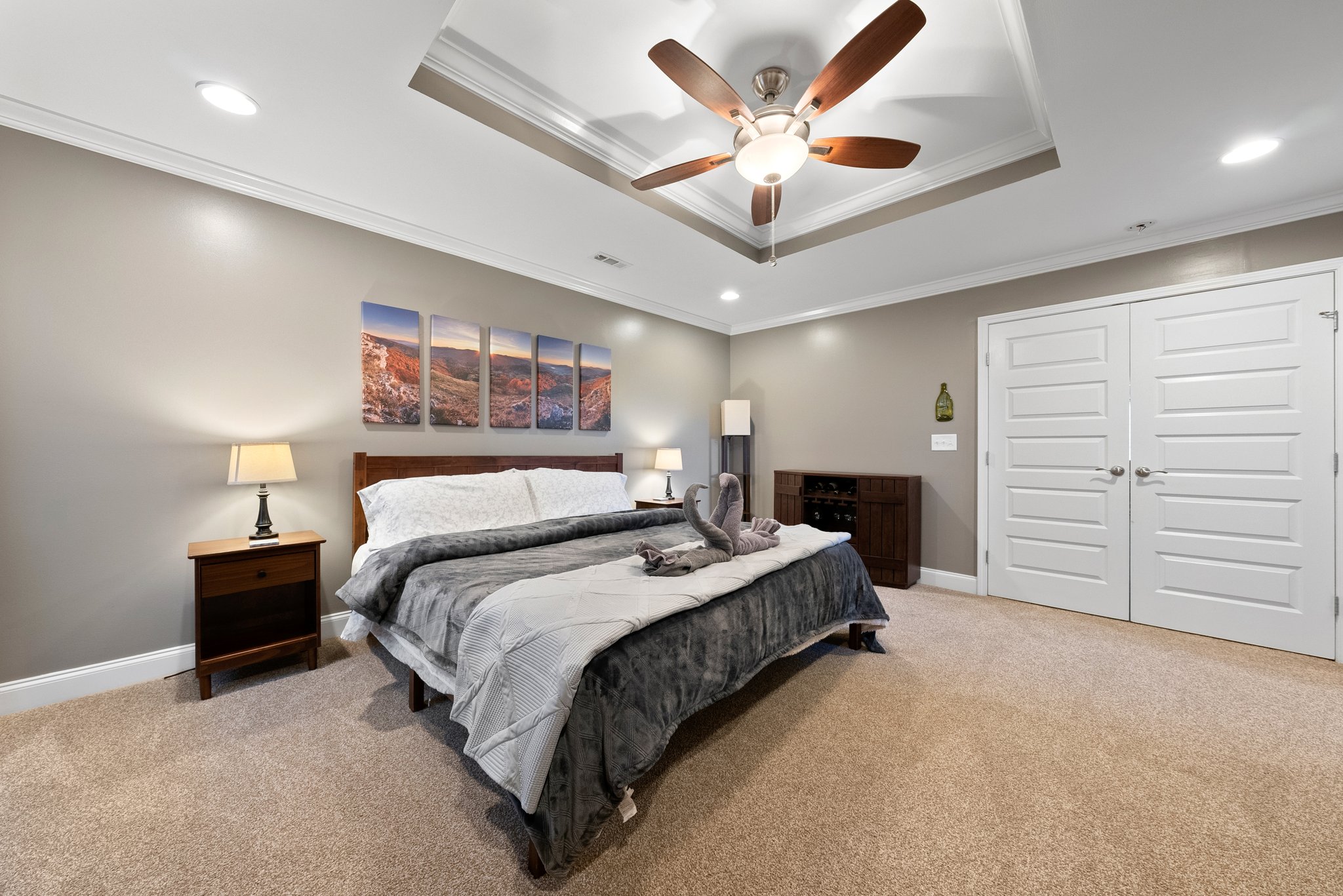 King bed in master bedroom with ceiling fan and modern d?cor