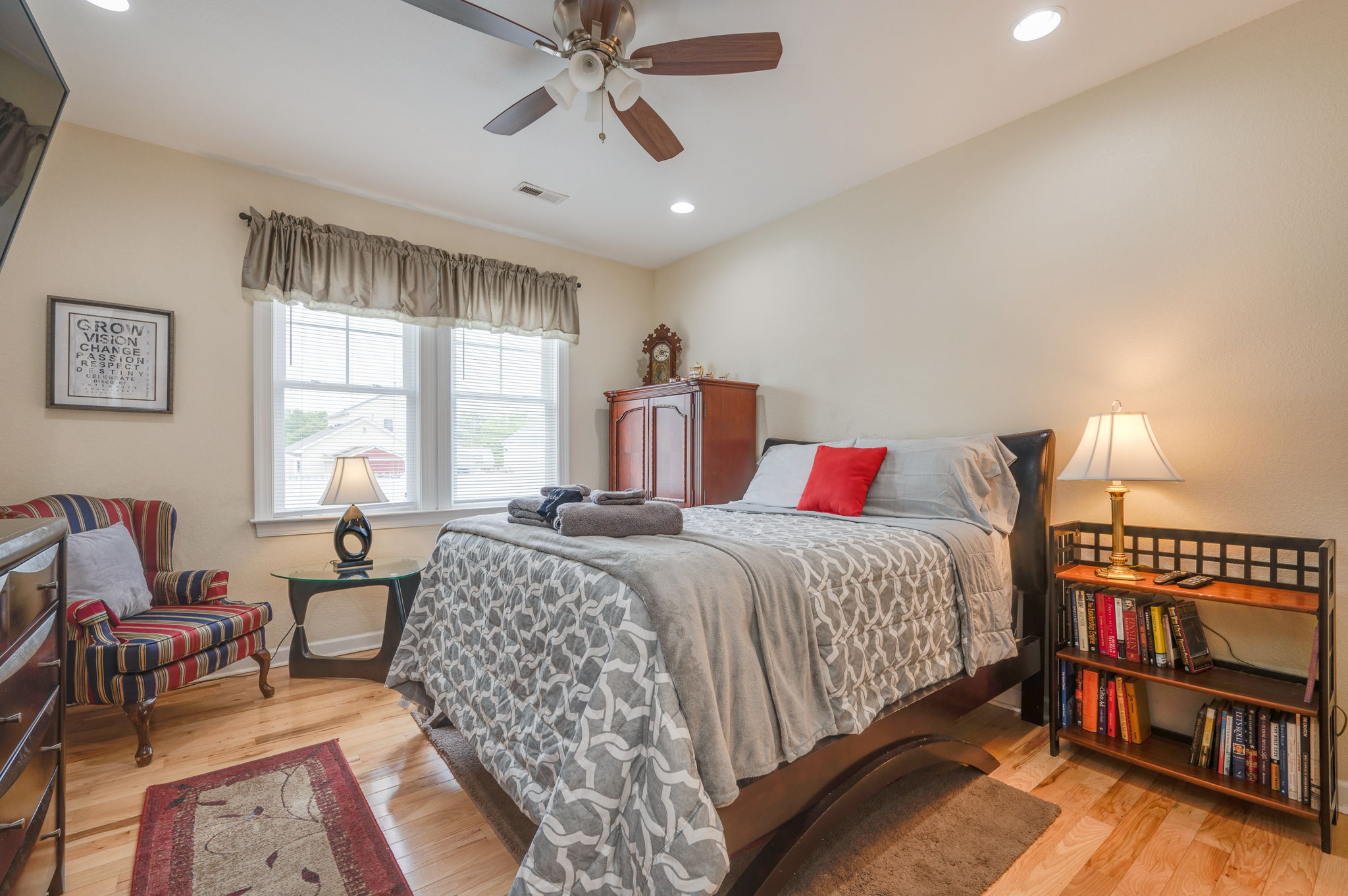 Spacious bedroom with queen bed, large windows, and cozy reading nook.