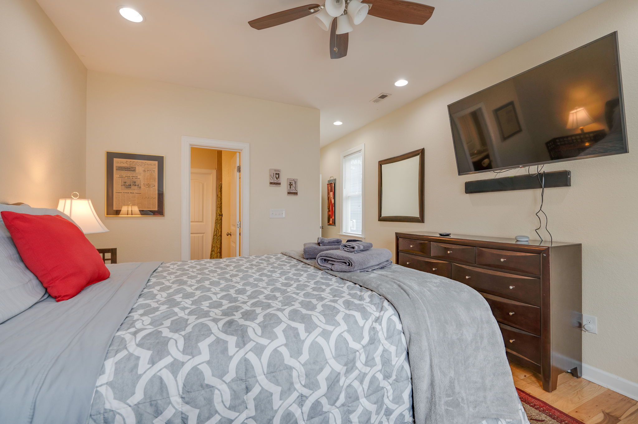Alternate view of bedroom featuring a wall-mounted TV and wooden dresser.