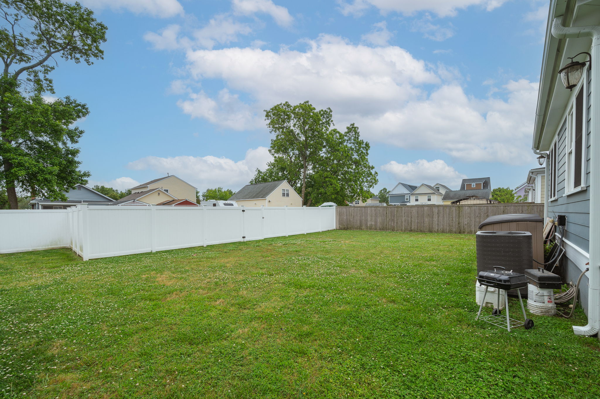 Large fenced backyard with open green space, perfect for outdoor activities.