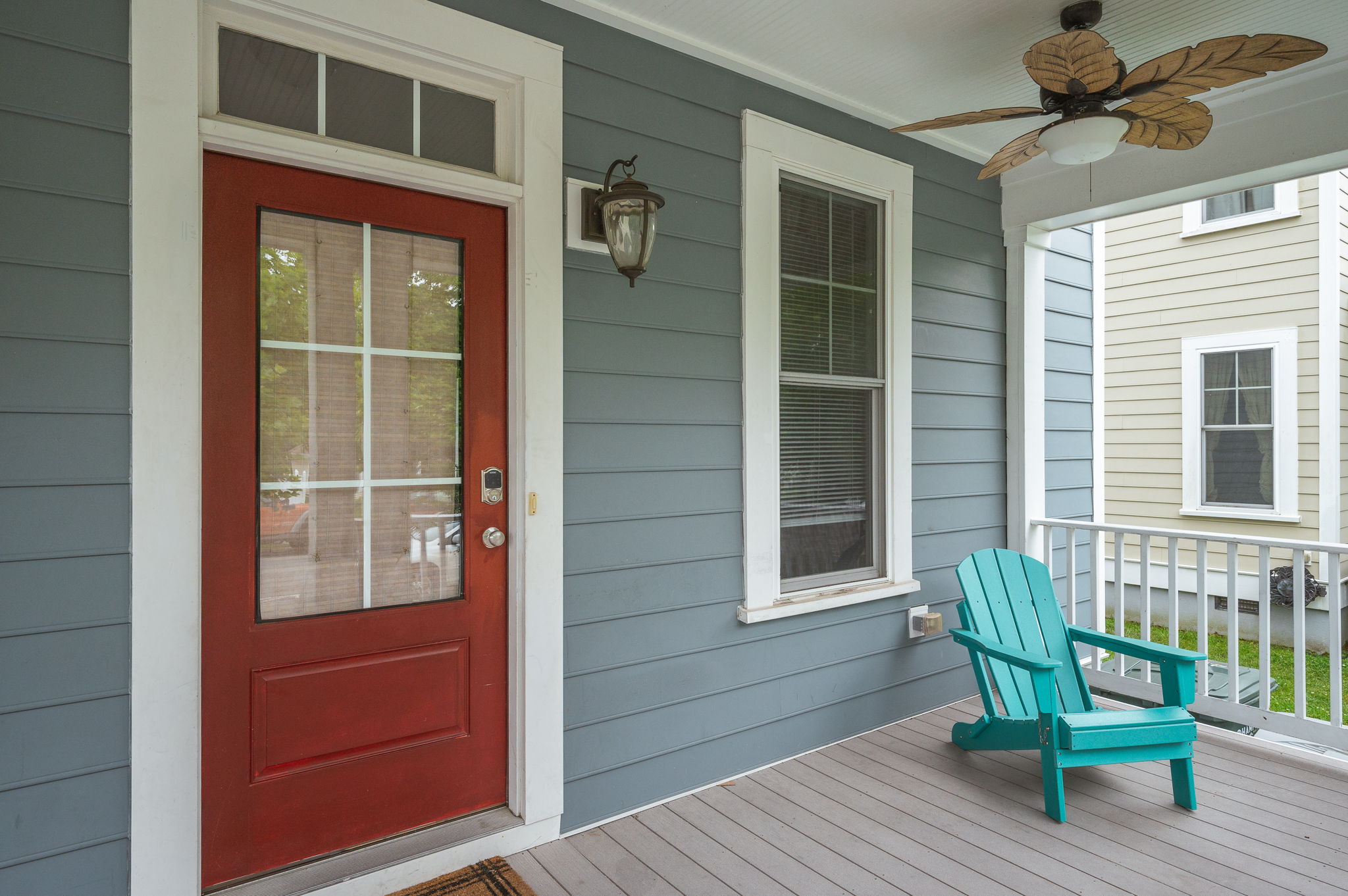 Close-up of a red front door with a keypad lock on a blue duplex.