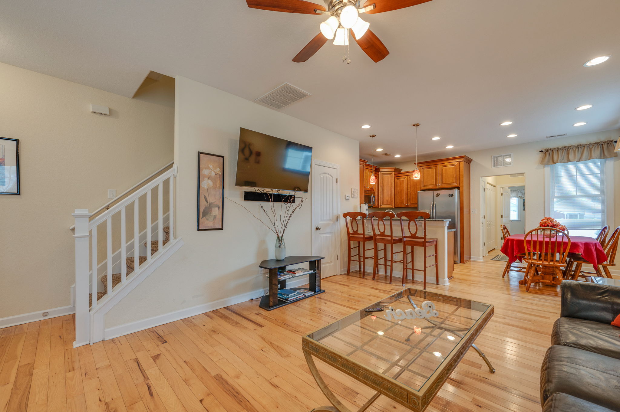 Modern open living area with mounted TV and kitchen bar seating.