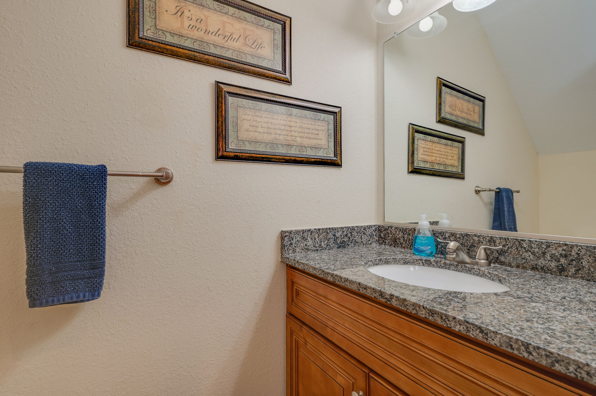 Modern bathroom with granite countertops, wooden vanity, and stylish decor.