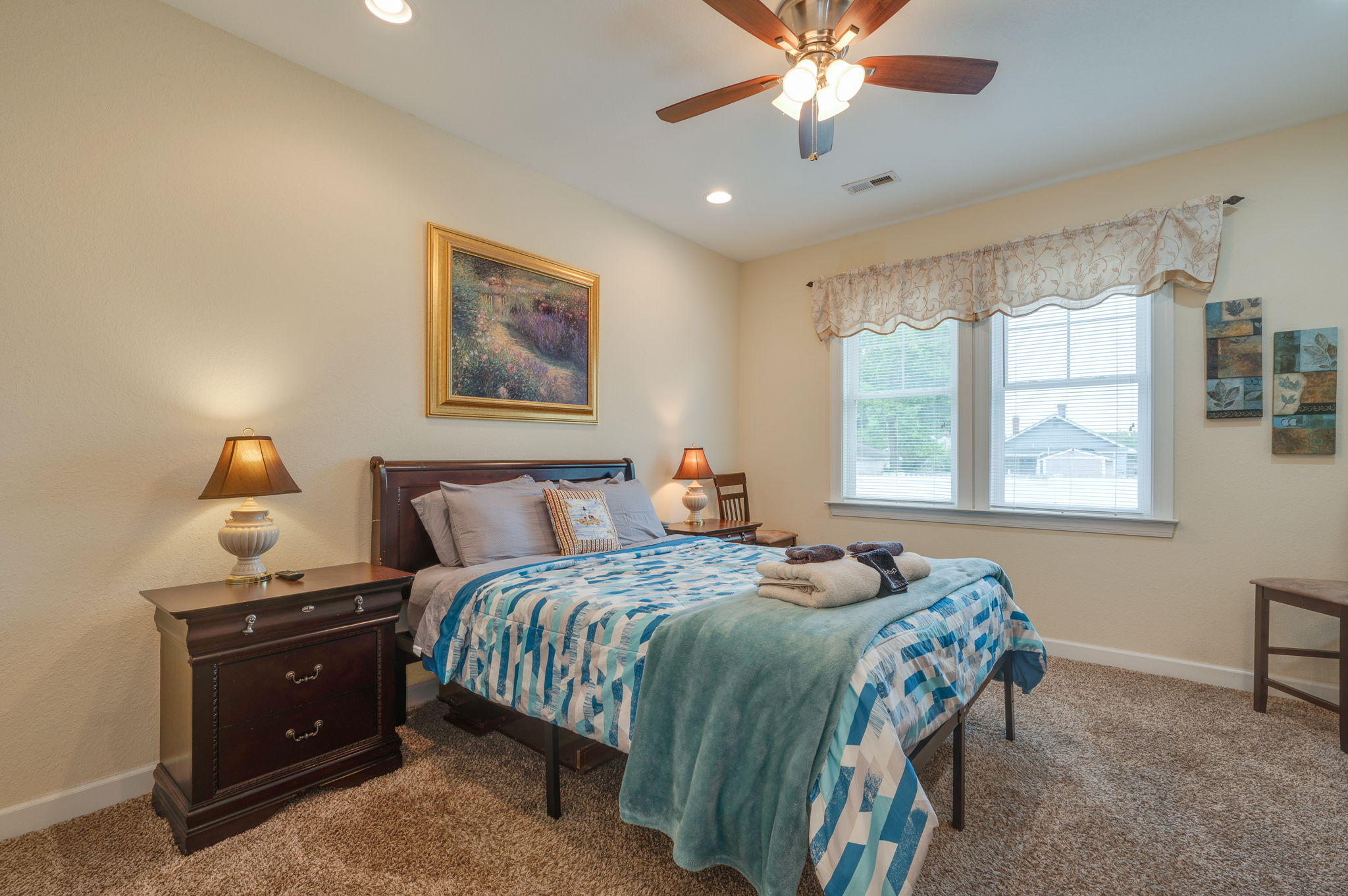 Cozy bedroom with a queen-size bed, bedside lamps, and warm lighting.