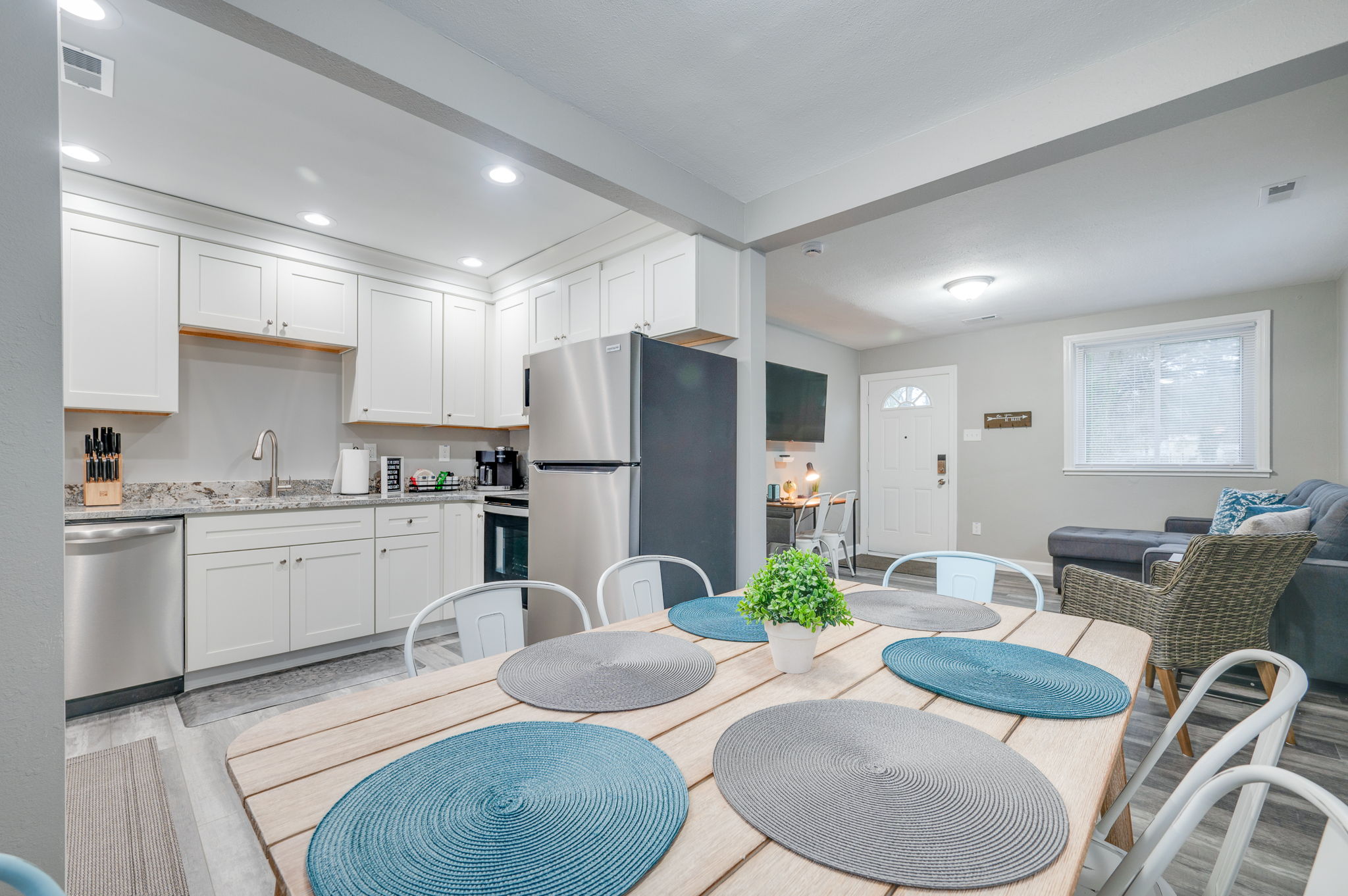 Spacious kitchen with white cabinets, stainless steel appliances, and granite countertops.