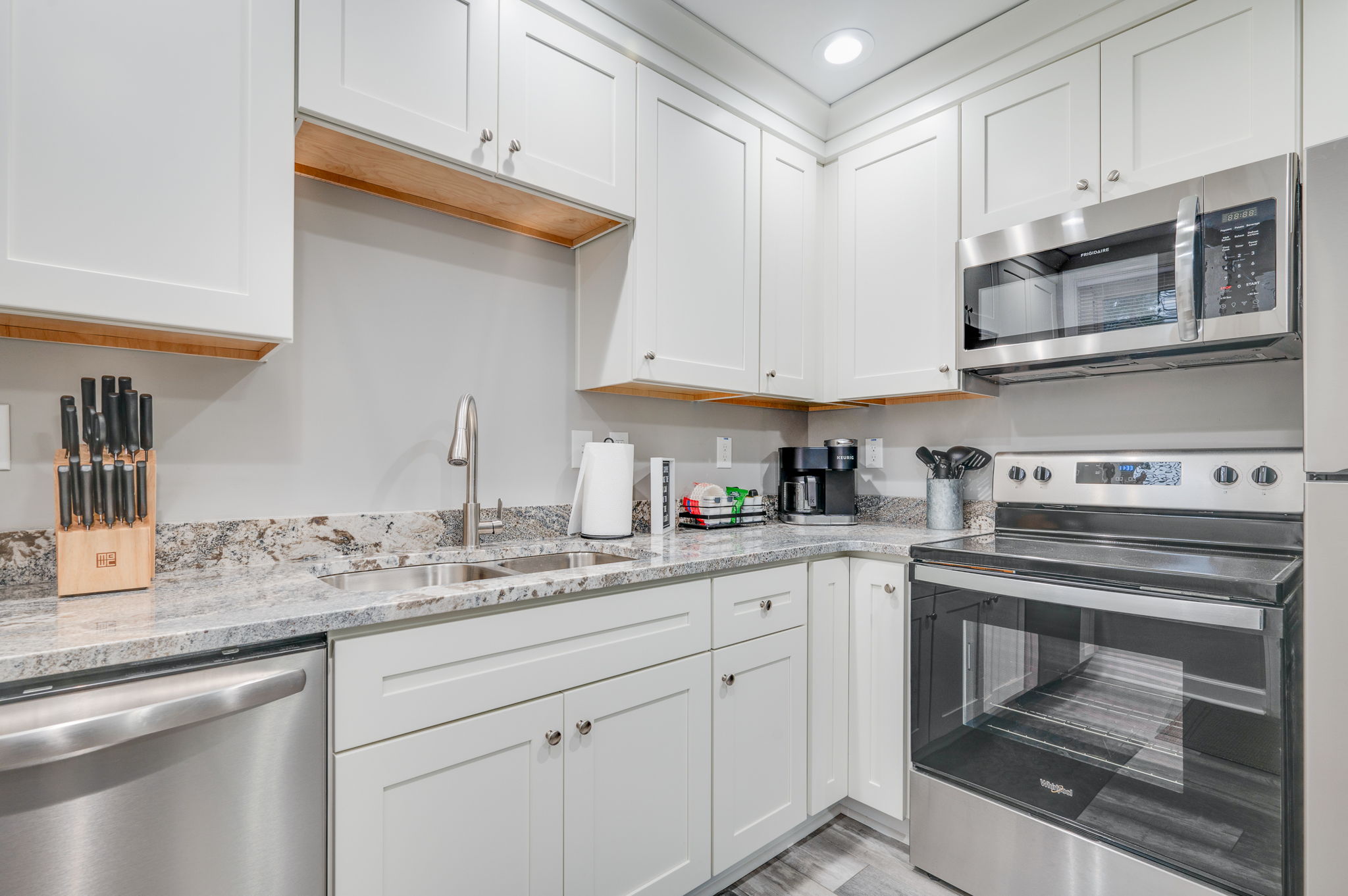 Fully equipped kitchen with stainless steel appliances and bright lighting.