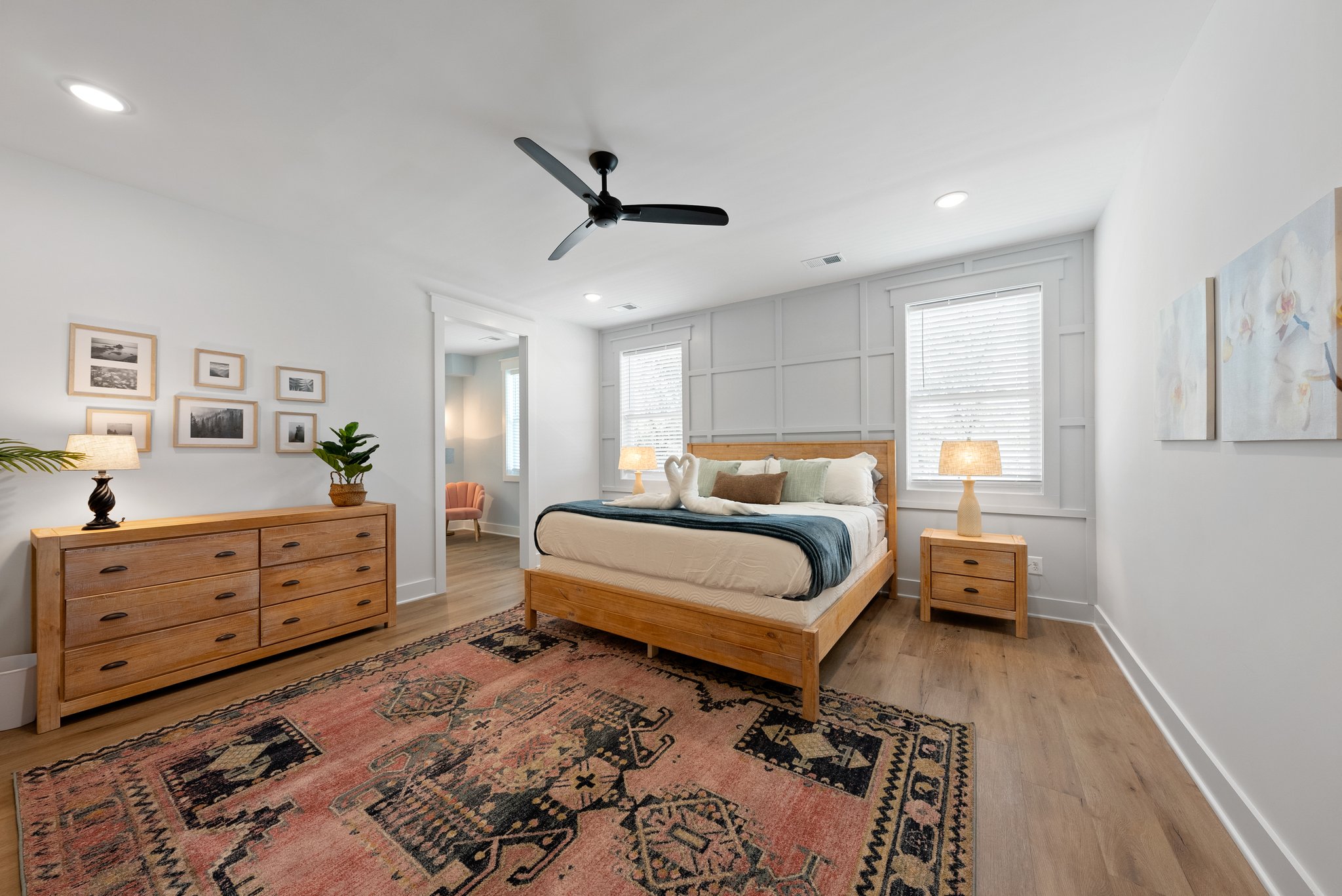 Master bedroom with wooden furniture, vintage rug, and decorative wall art
