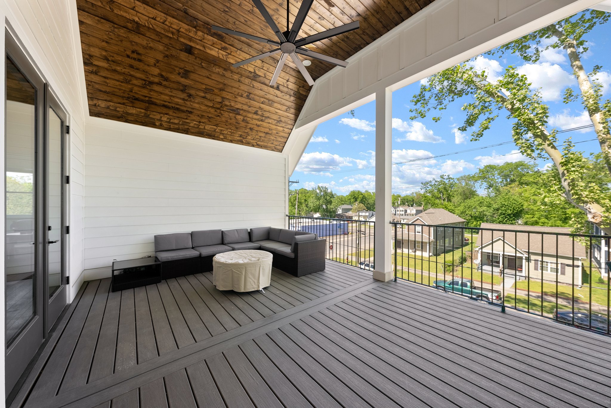Covered Balcony Lounge Area with Large Ceiling Fan and Gray Sectional