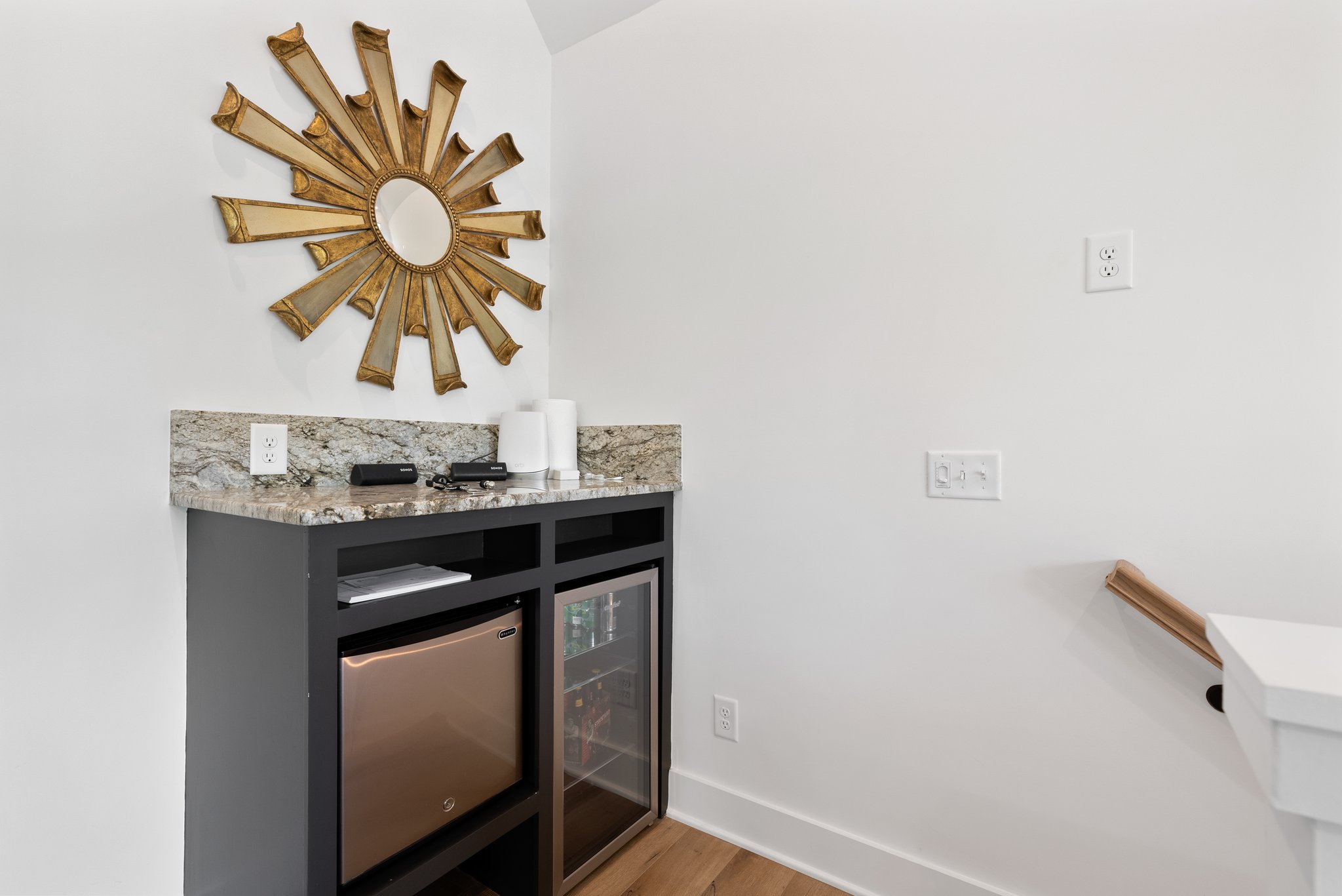 Mini Bar Area with Golden Sunburst Mirror and Mini Fridge