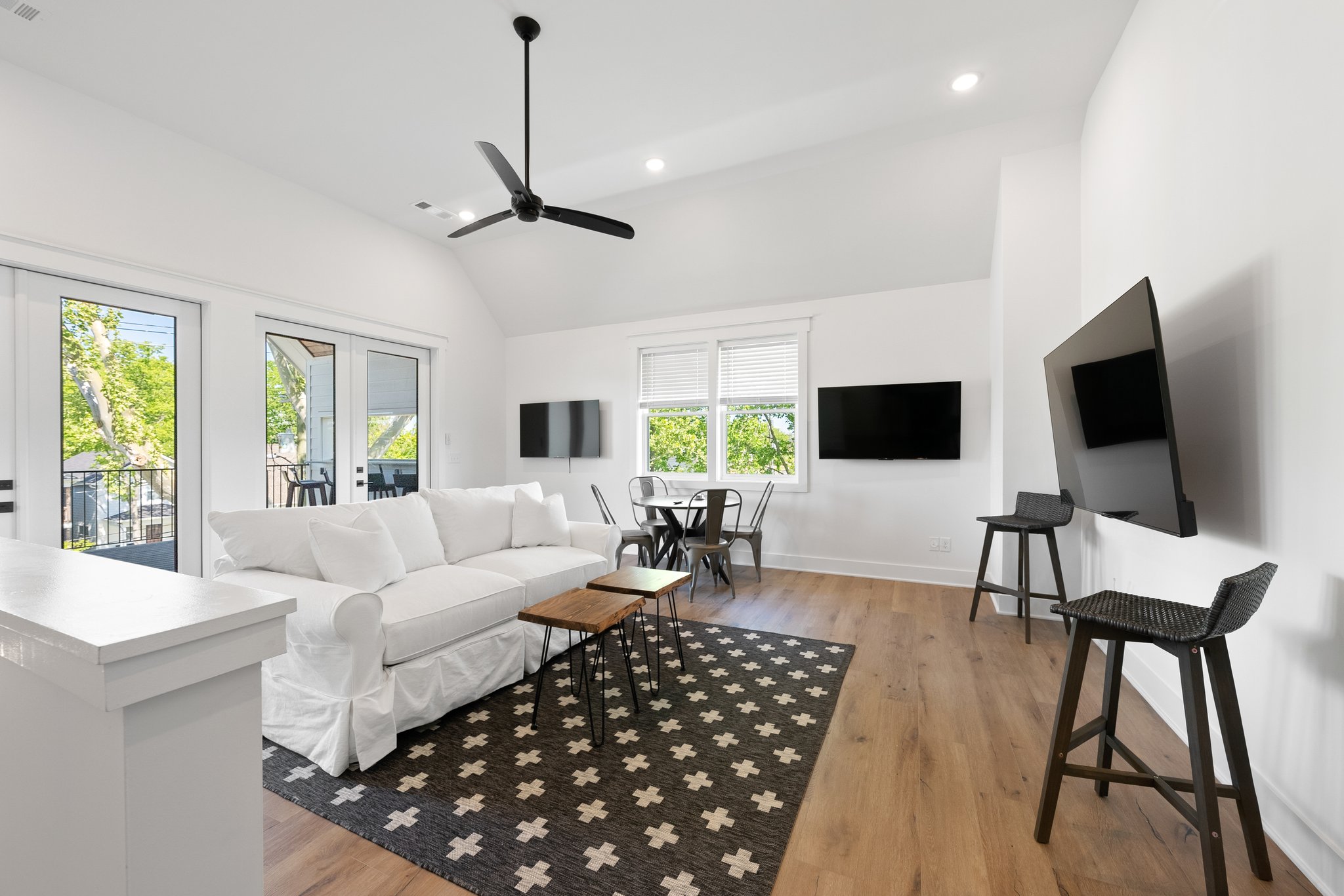 Contemporary loft area with mounted TVs, a dining table, and a cozy seating area.