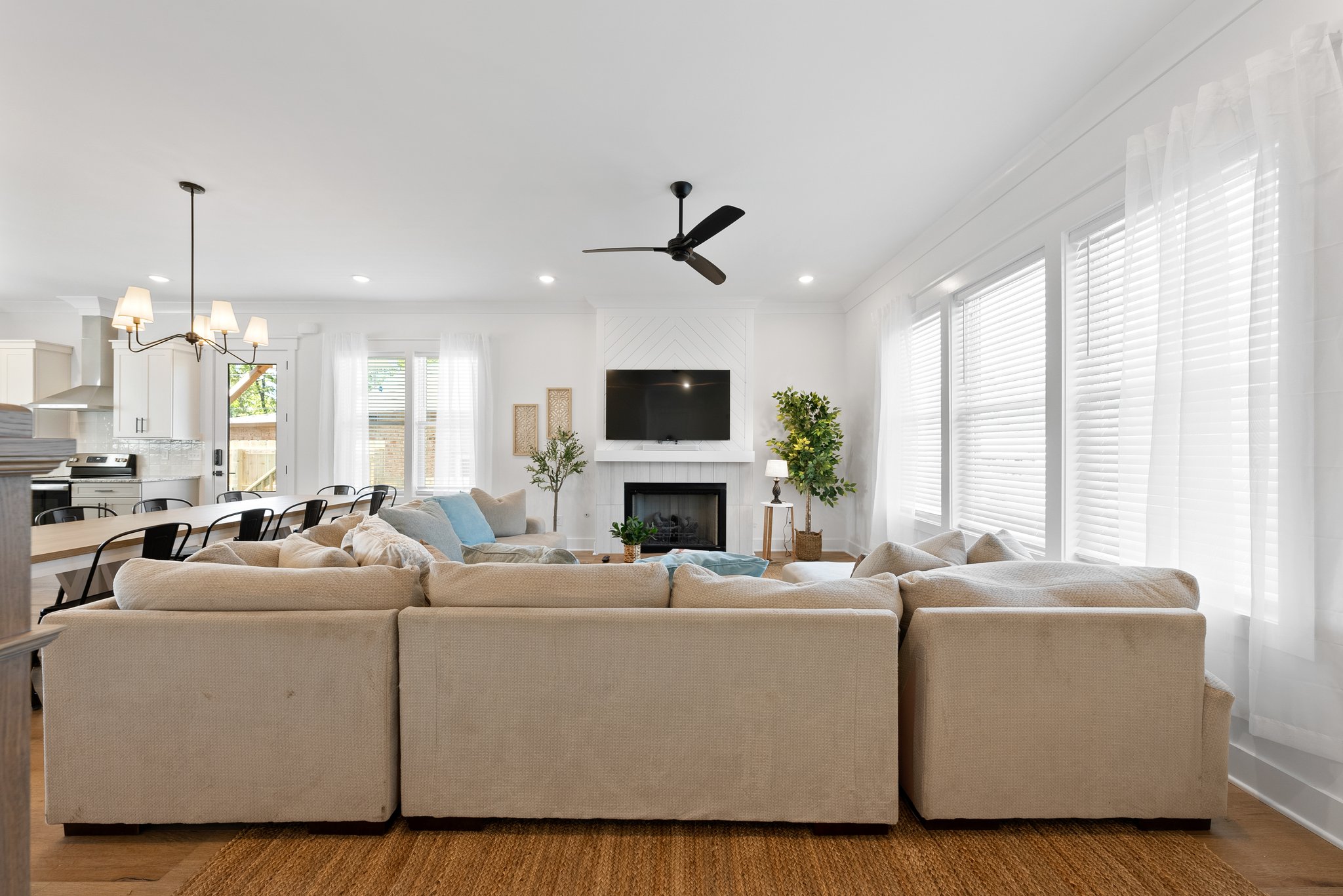 Spacious living room with a cozy sectional sofa, fireplace, and a mounted flat-screen TV.