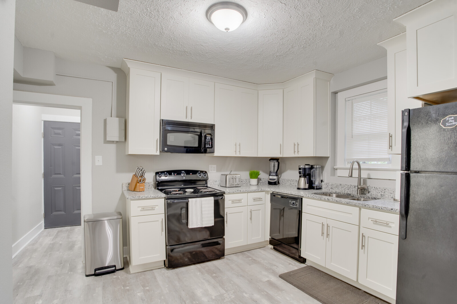 Modern kitchen with white cabinets, black appliances, and granite countertops
