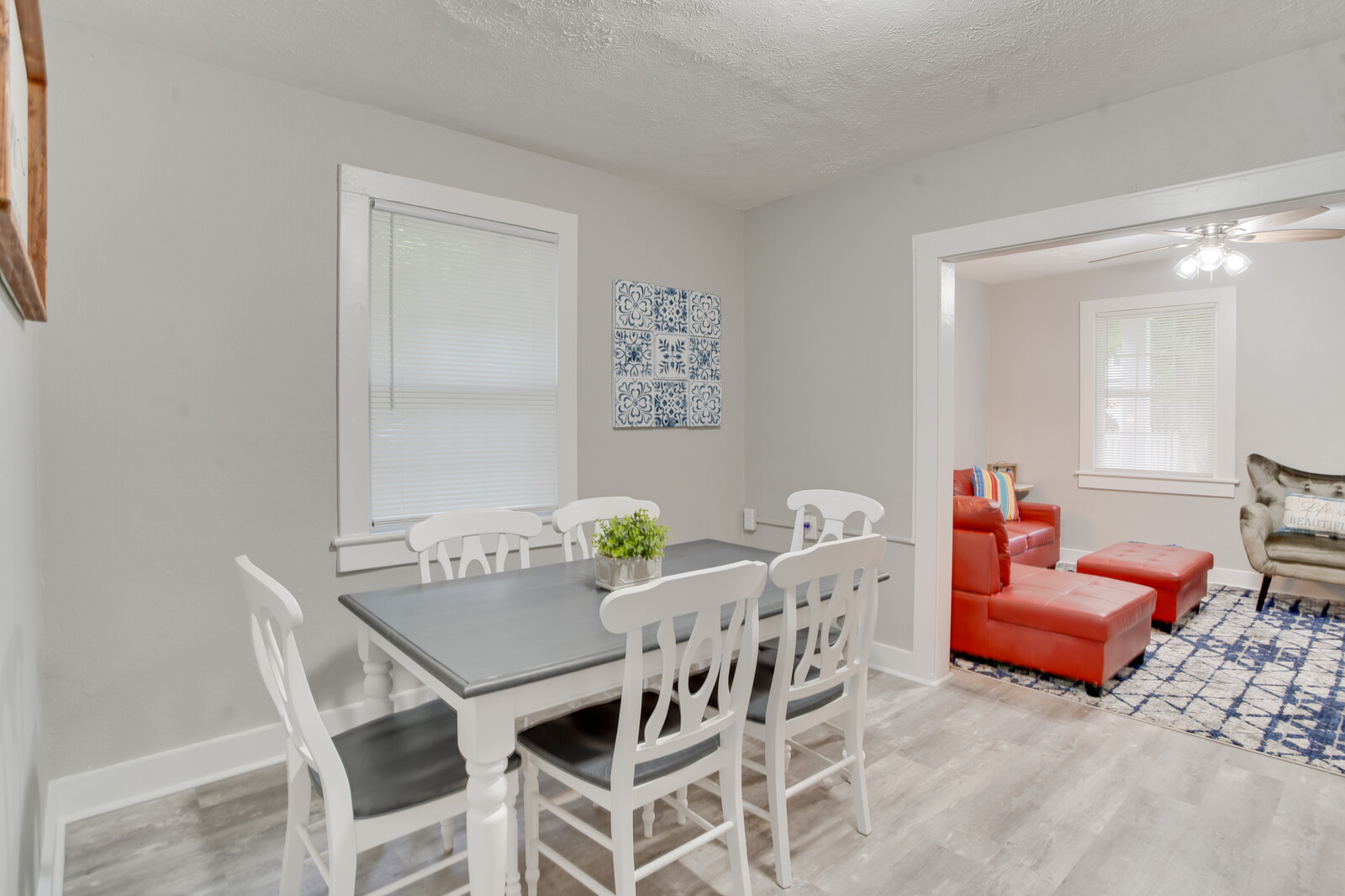 Elegant dining area with white table, chairs, and welcoming wall decor