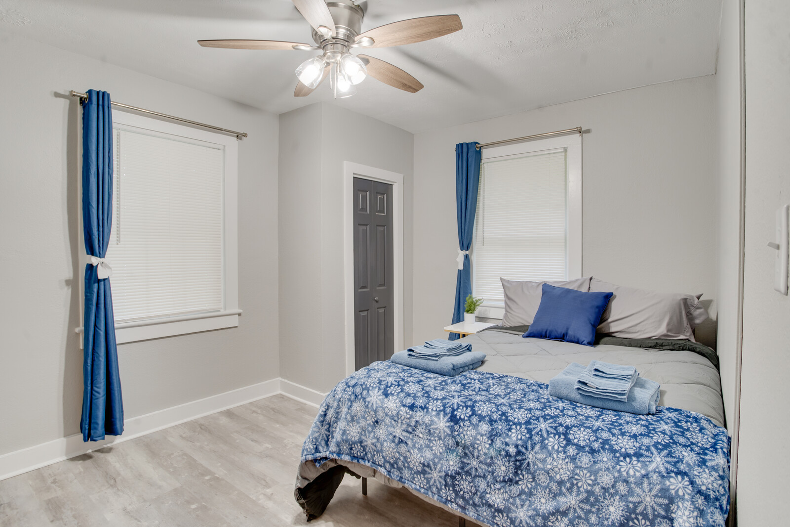 Comfortable bedroom with a cozy bed, blue curtains, and modern touches