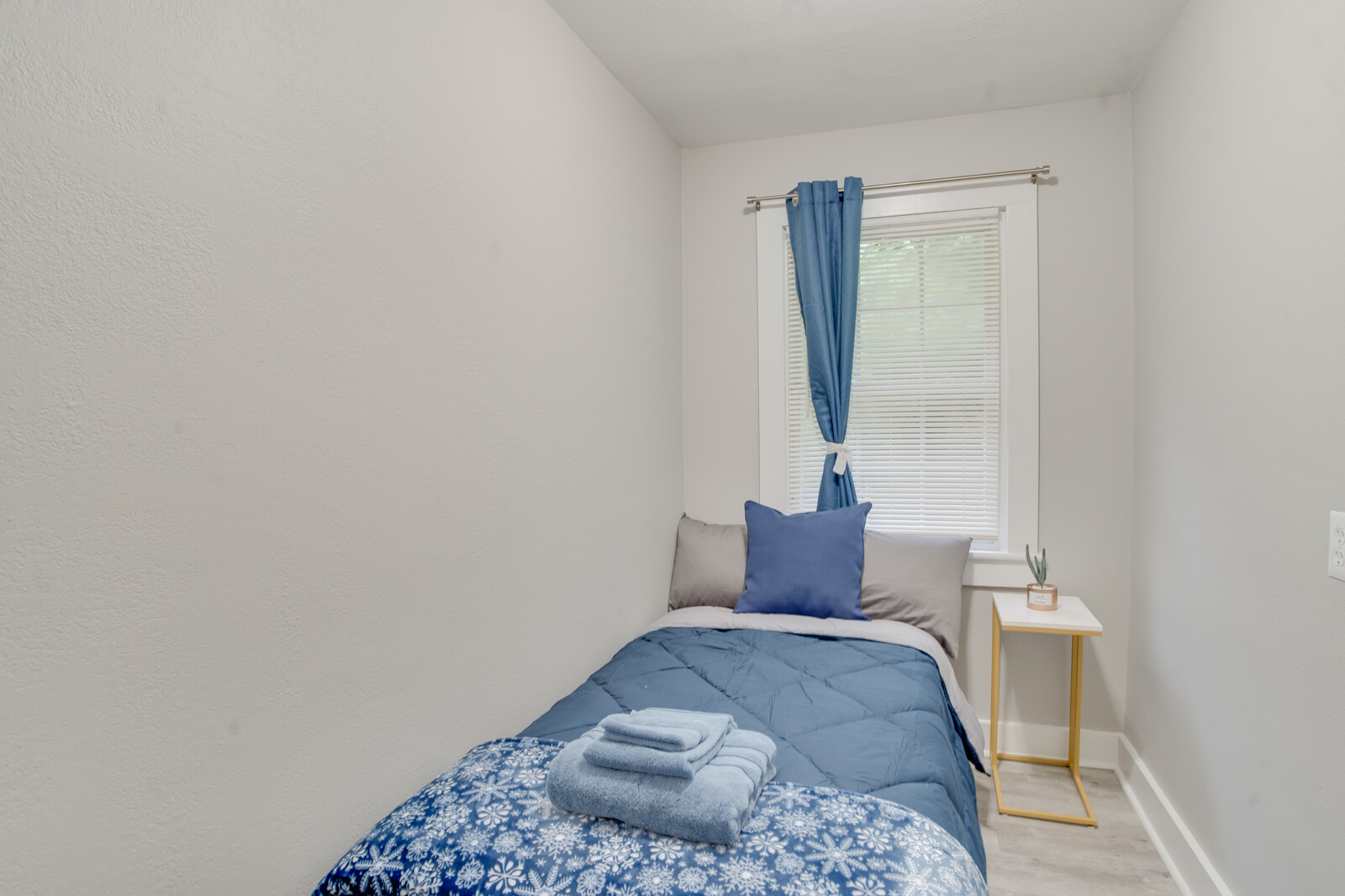 Cozy bedroom with a blue and gray color scheme and soft bedding