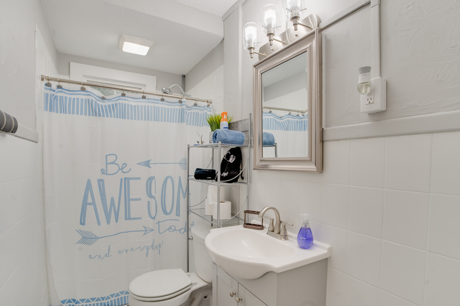 Modern bathroom with a decorative shower curtain and vanity mirror