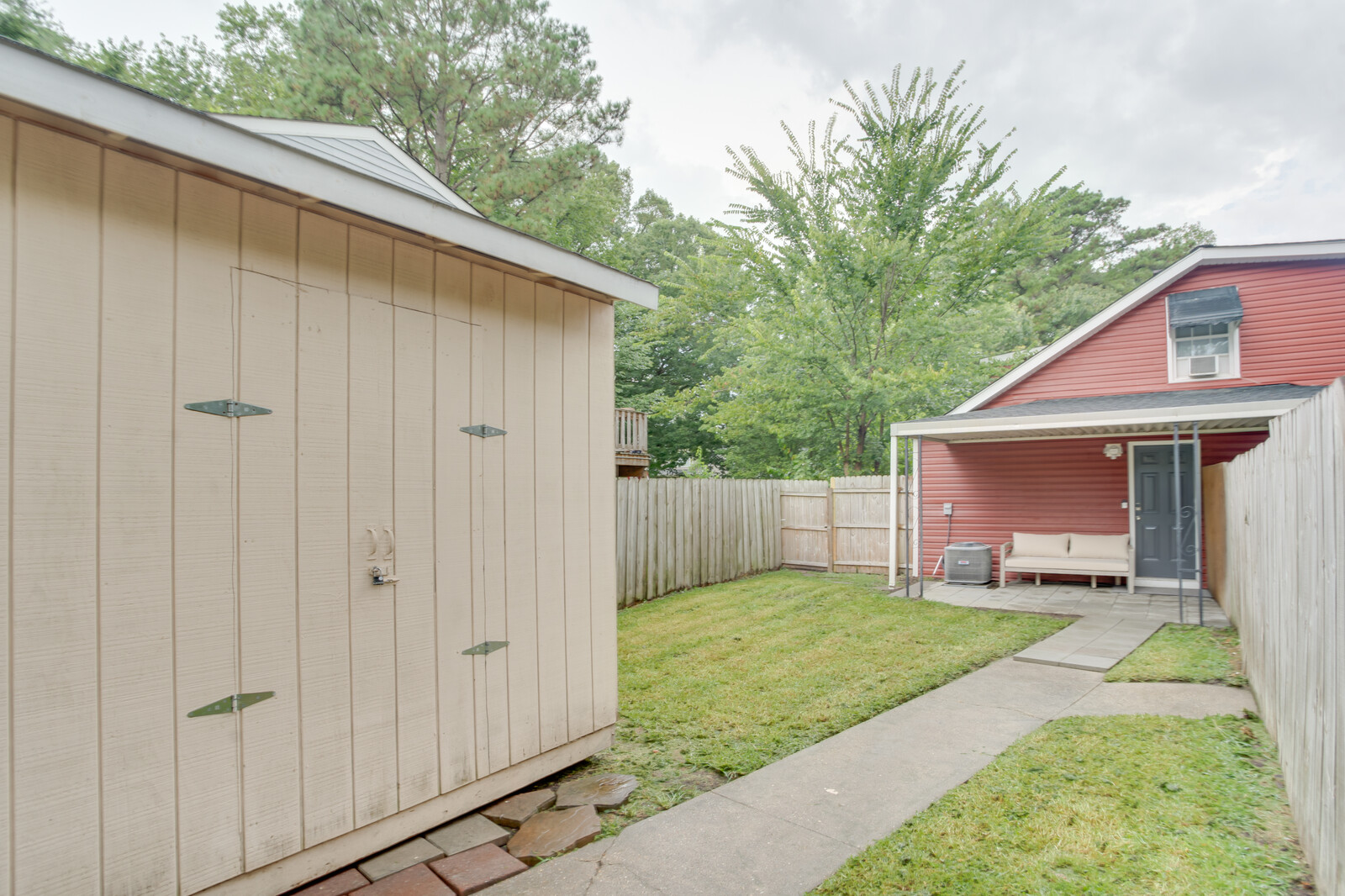 Storage shed and backyard pathway leading to the patio and home entrance