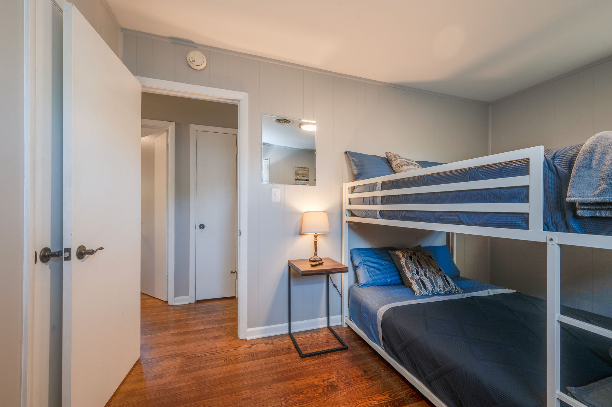 Bunk bed room with a modern design, nightstand, and soft lighting for a cozy feel.