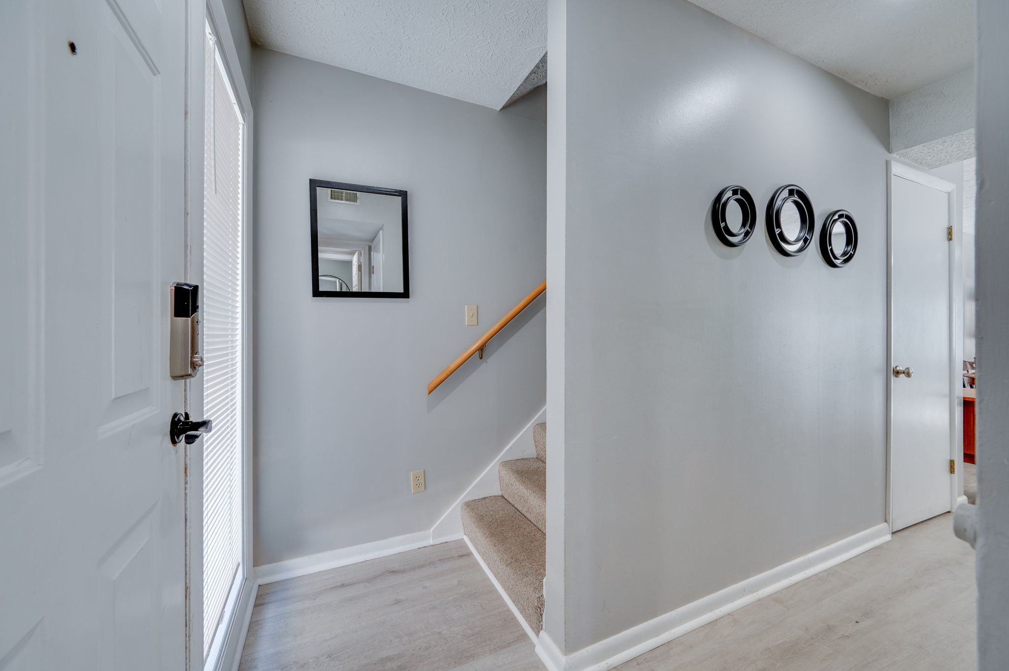 Modern townhouse entryway with staircase and wall decor