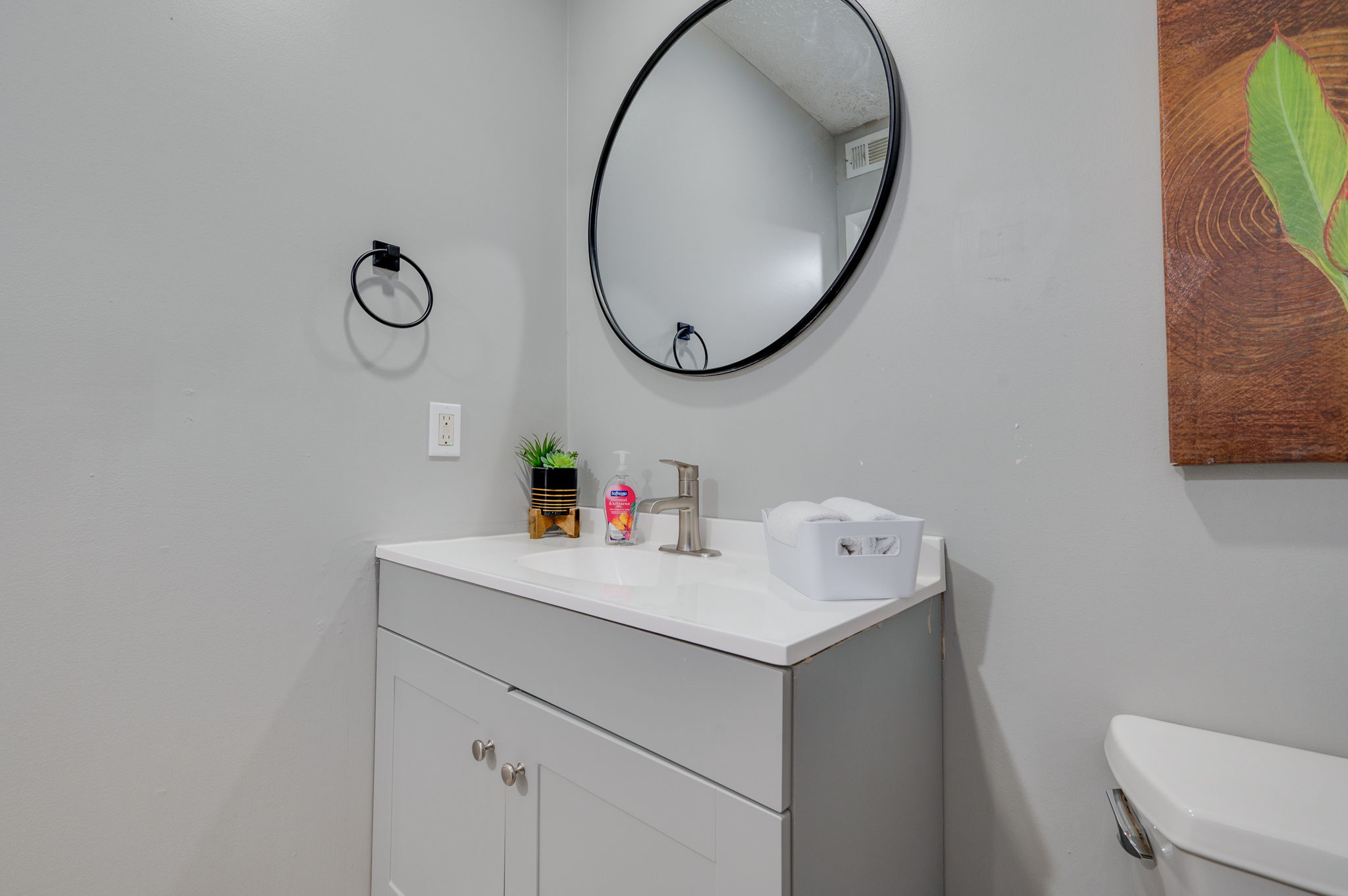 Contemporary bathroom with a round mirror and white vanity