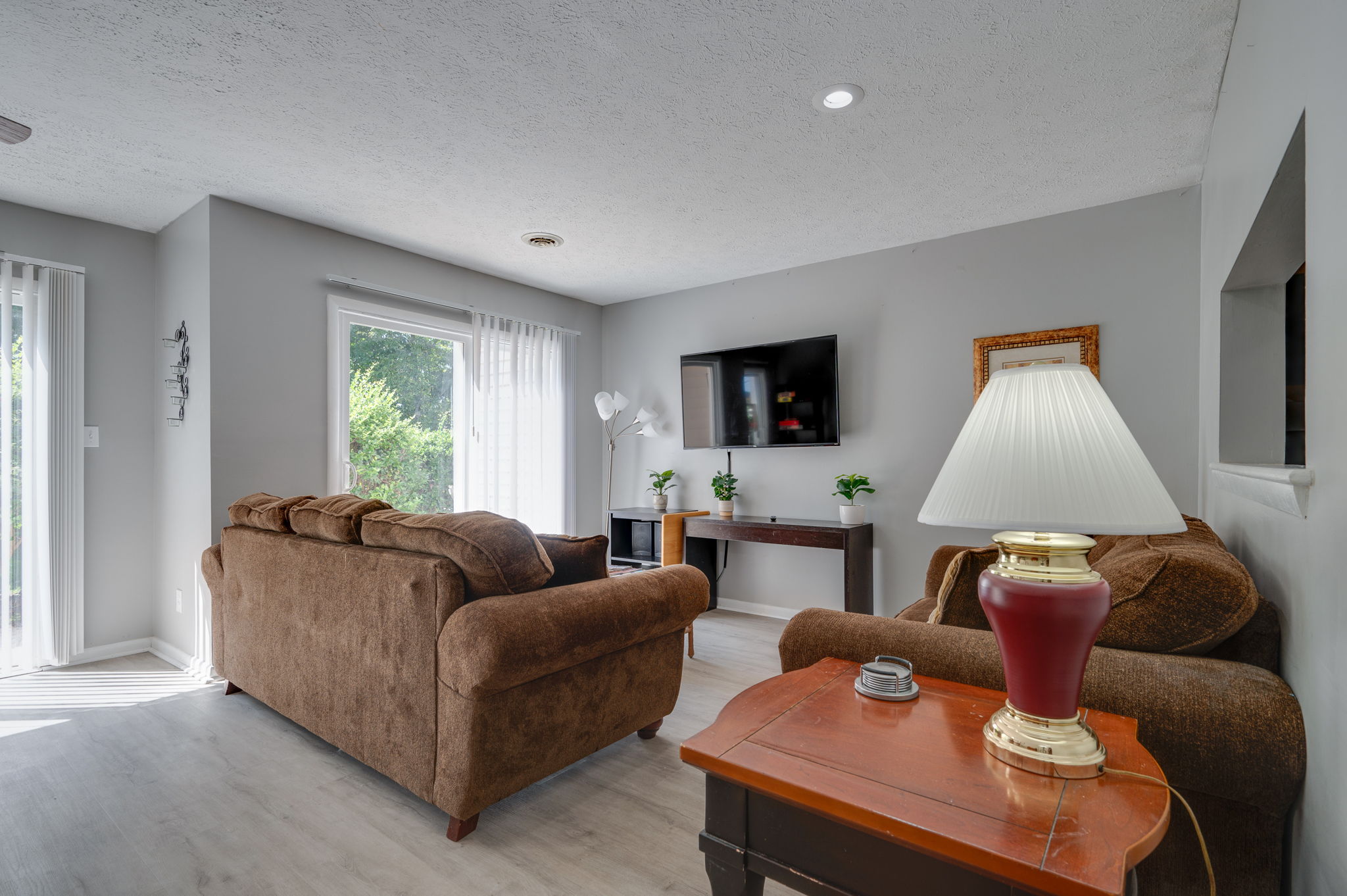 Cozy living room with brown sofas, TV, and natural light