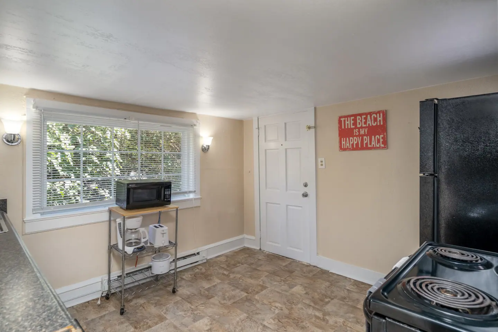 Kitchen corner with a microwave, coffee maker, and a window.