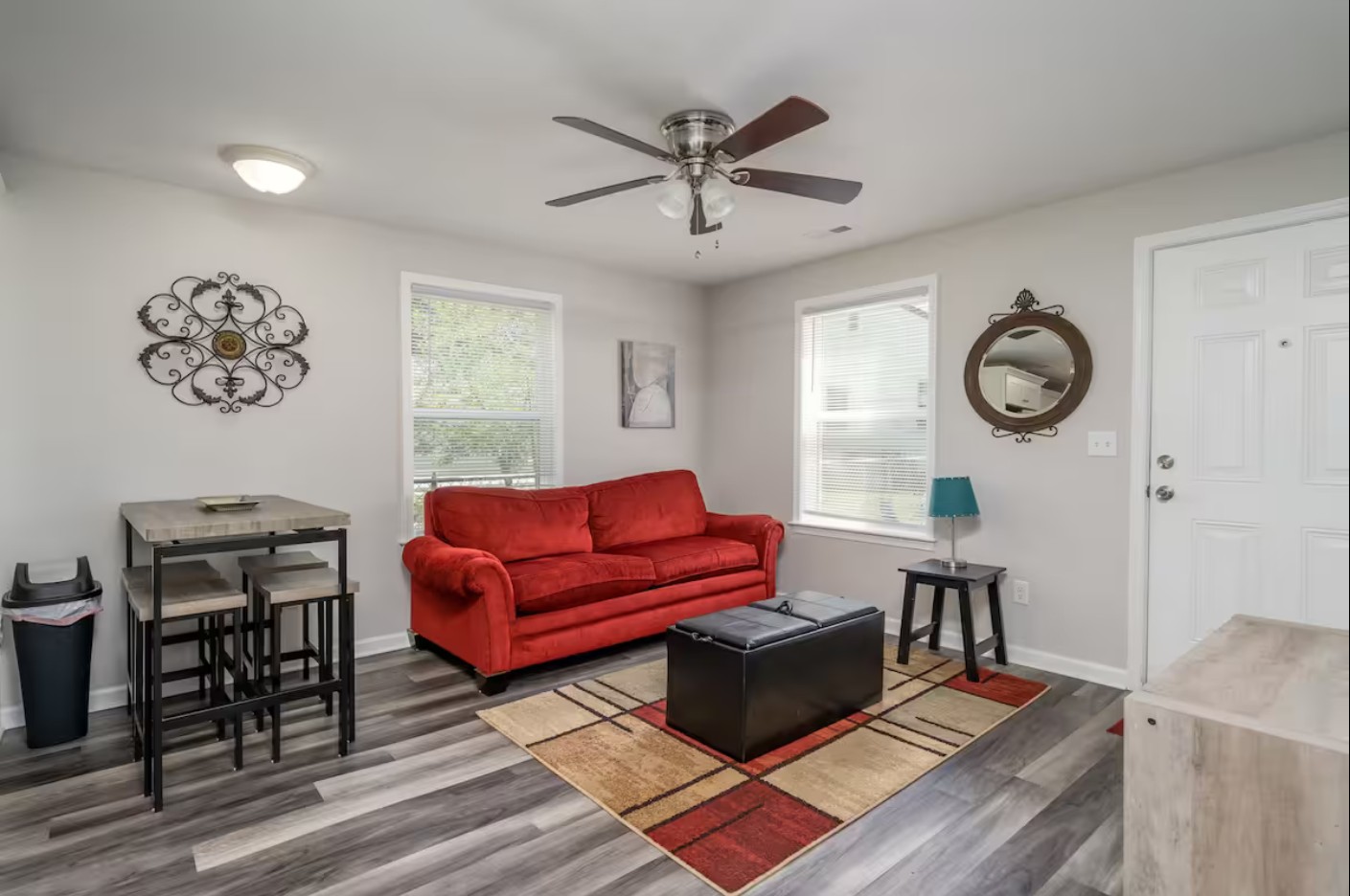 Open-concept living and kitchen area with modern furnishings and a red couch.