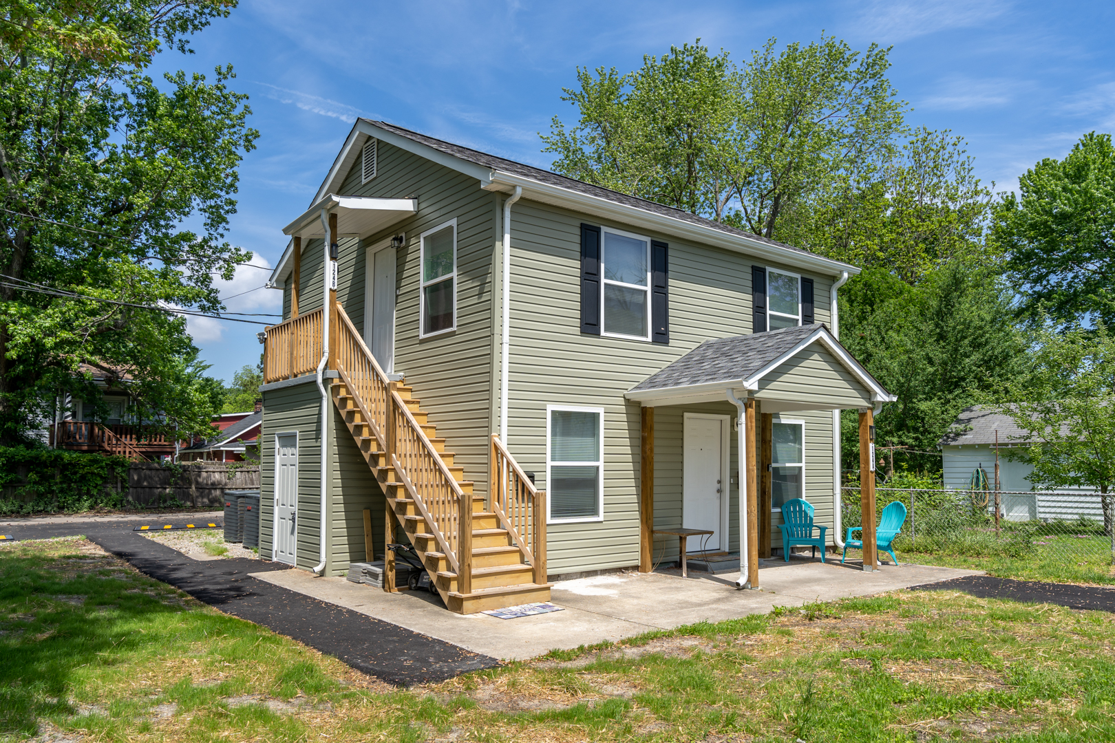 Side view of a two-story duplex with an exterior staircase leading to the upper unit.