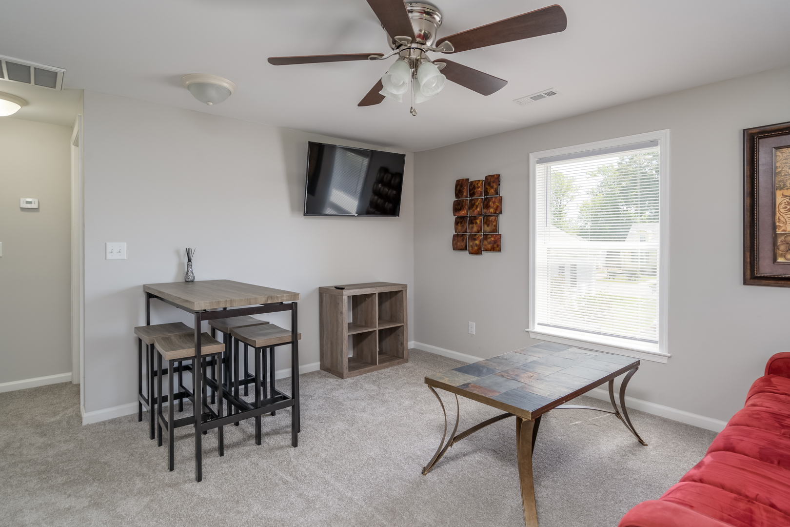 Dining area with a mounted TV, wooden table, and stylish decor.