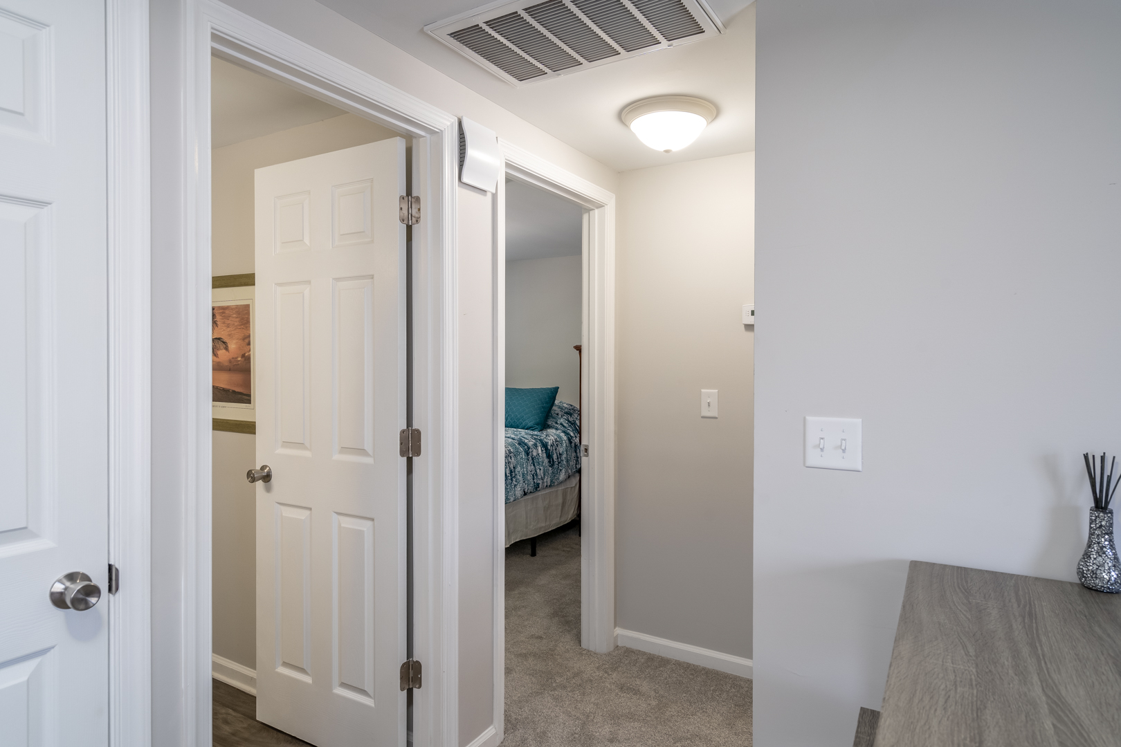 Hallway leading to bedrooms, featuring white doors and a neutral color palette.