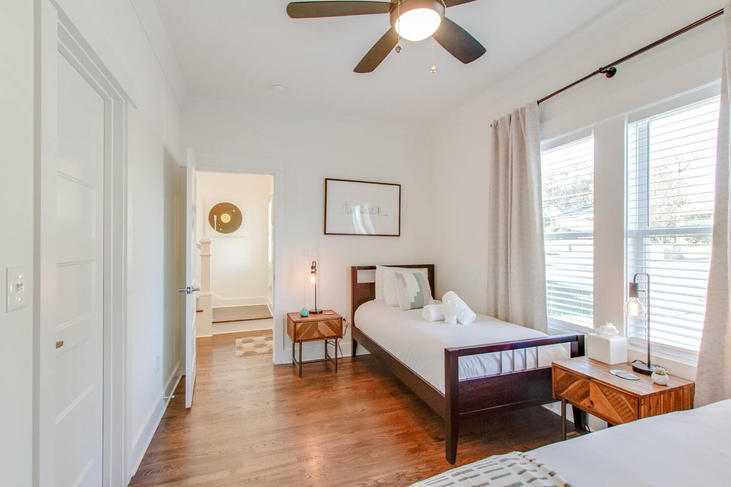 Well-lit bedroom with twin beds and warm wooden accents