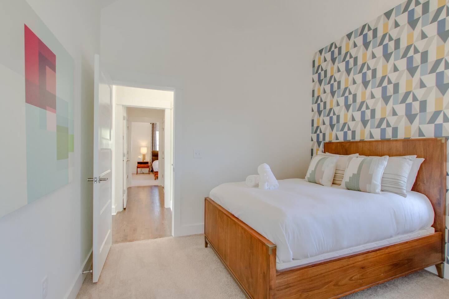 Contemporary bedroom with a geometric accent wall and wood bed frame