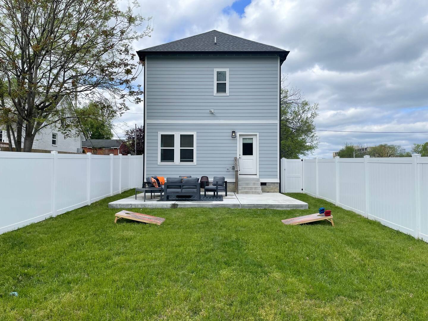 Spacious backyard with a patio seating area and lawn games