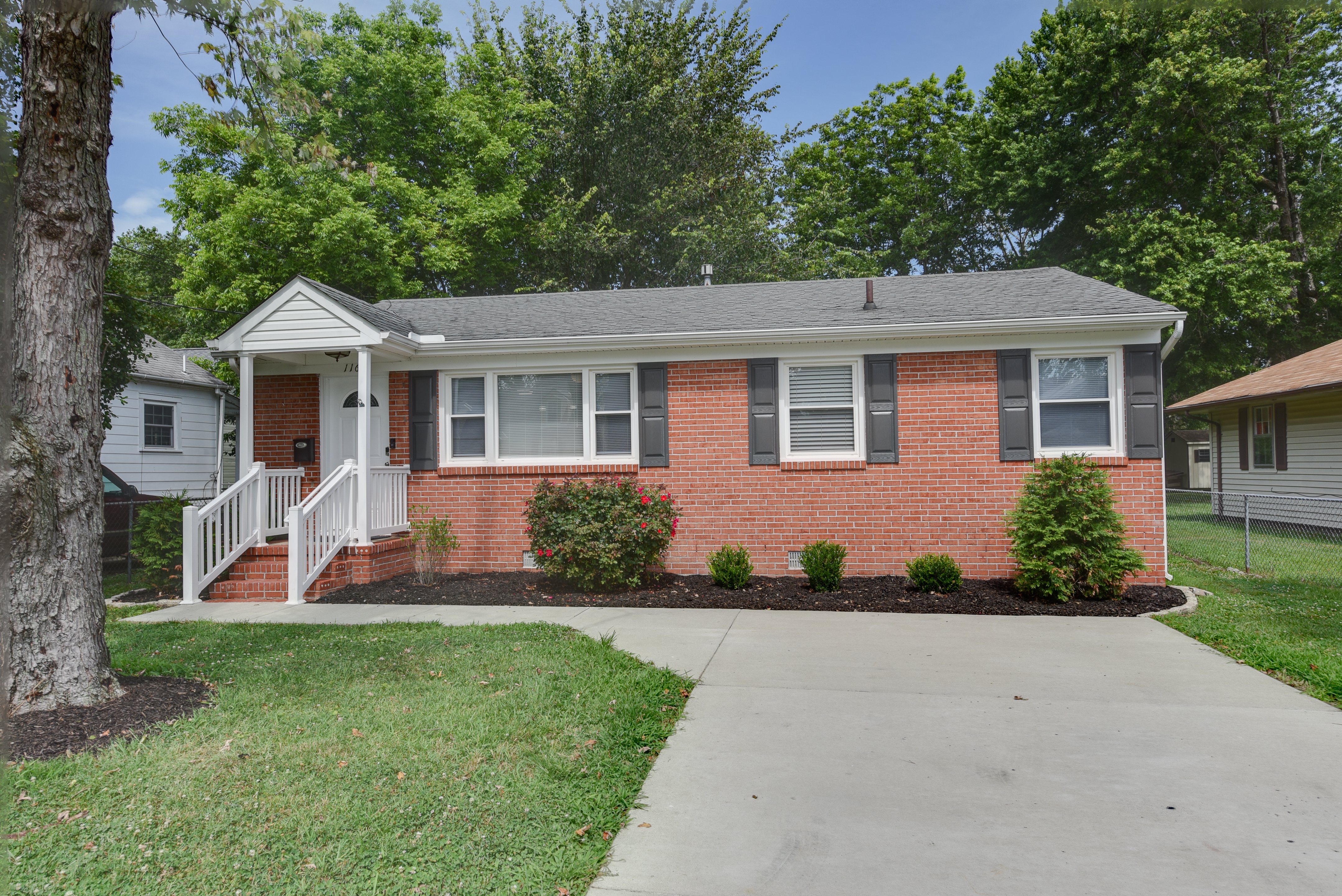 Brick home with a welcoming front porch and driveway