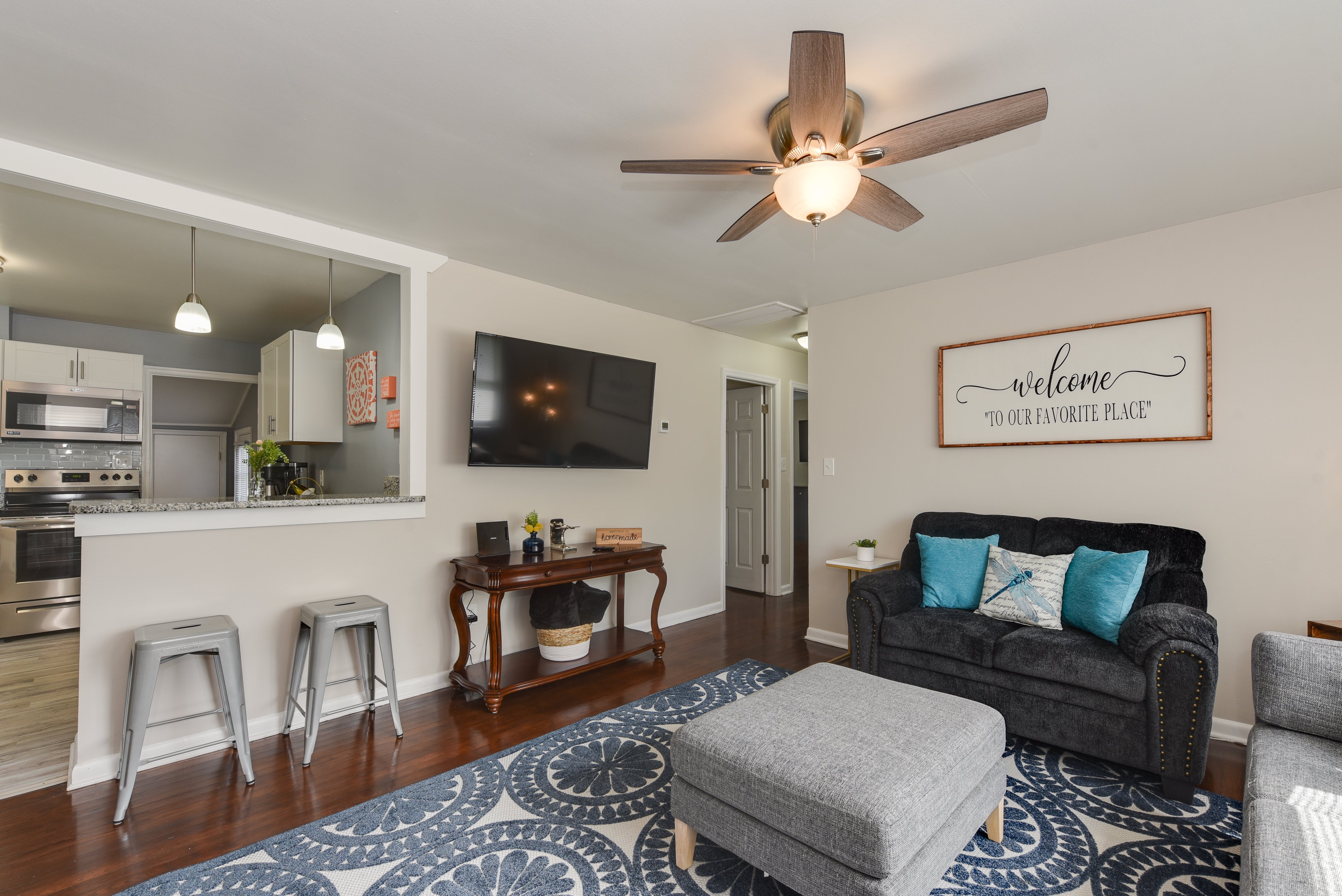 Open-concept living room with a TV and breakfast bar