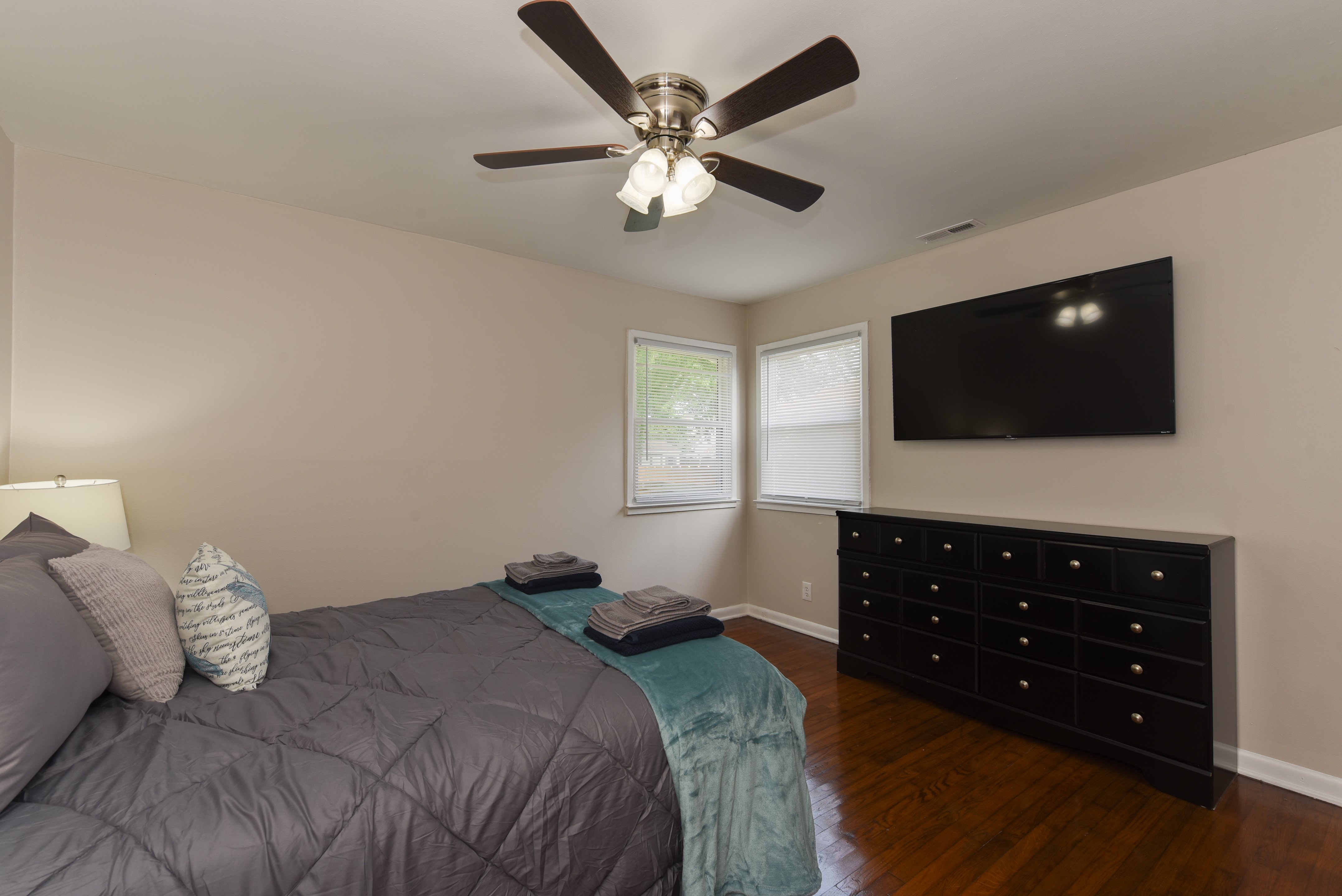 Master bedroom with a king-sized bed and mounted TV