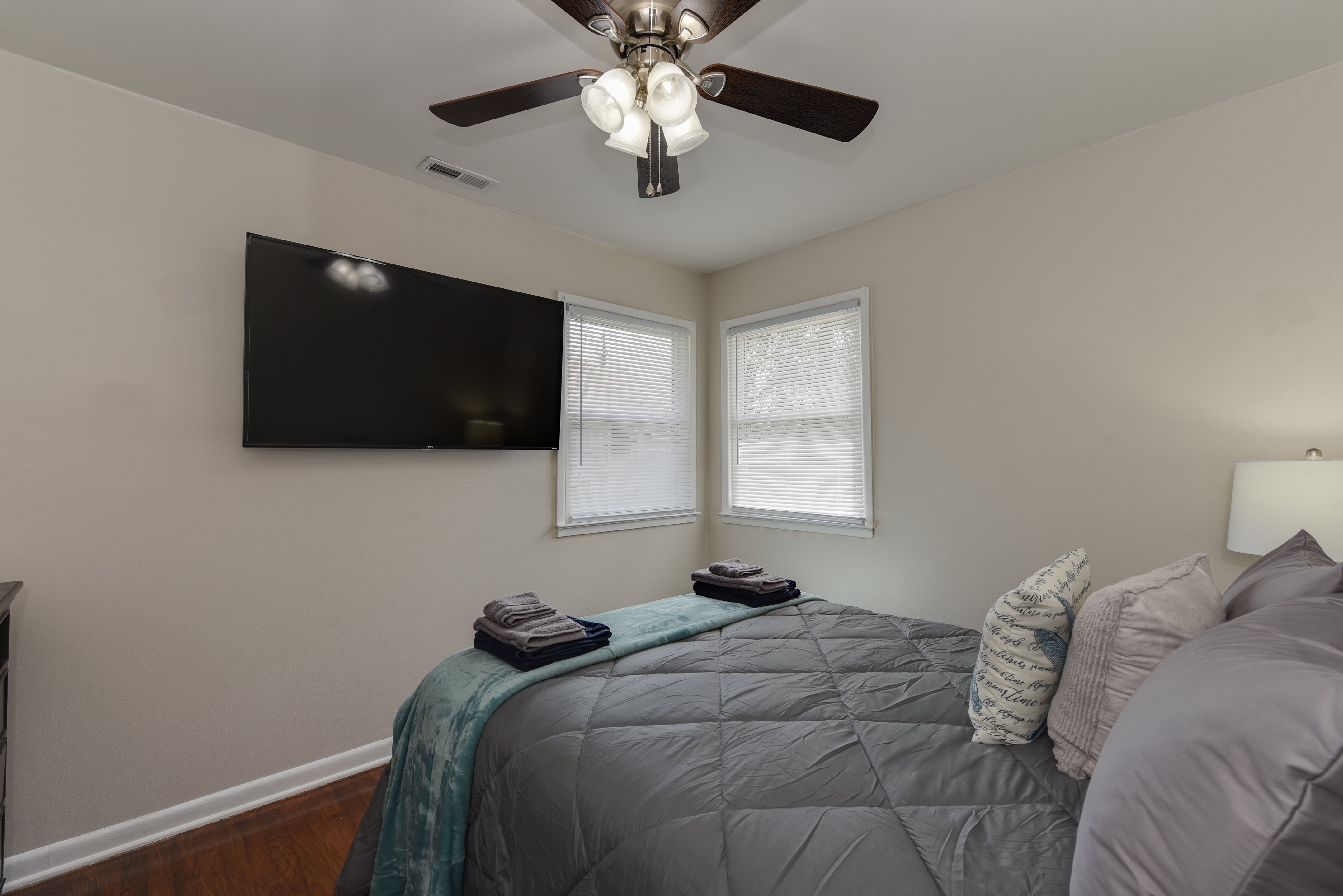 Bedroom with a cozy bed and TV mounted on the wall