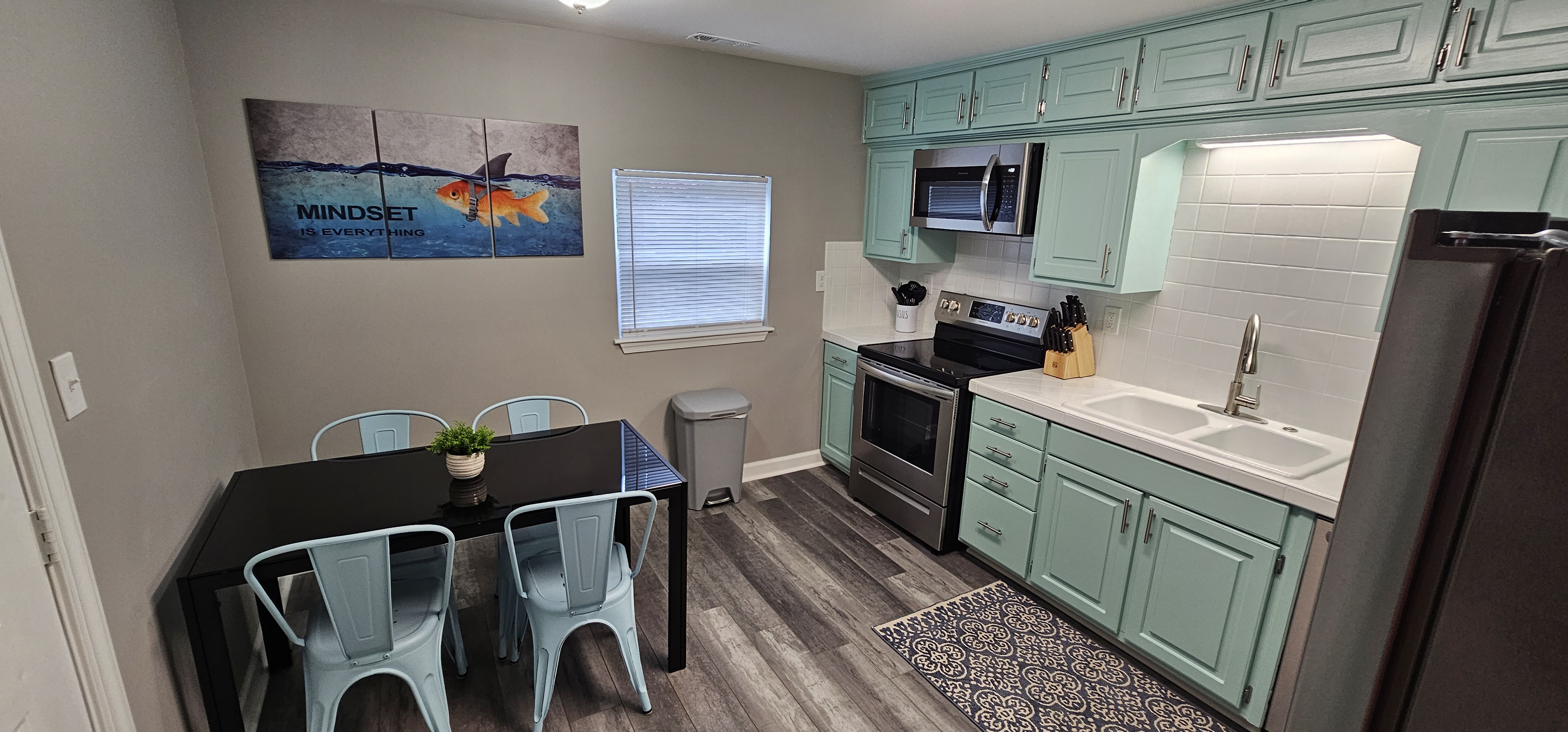 Modern kitchen with teal cabinets and stainless steel appliances