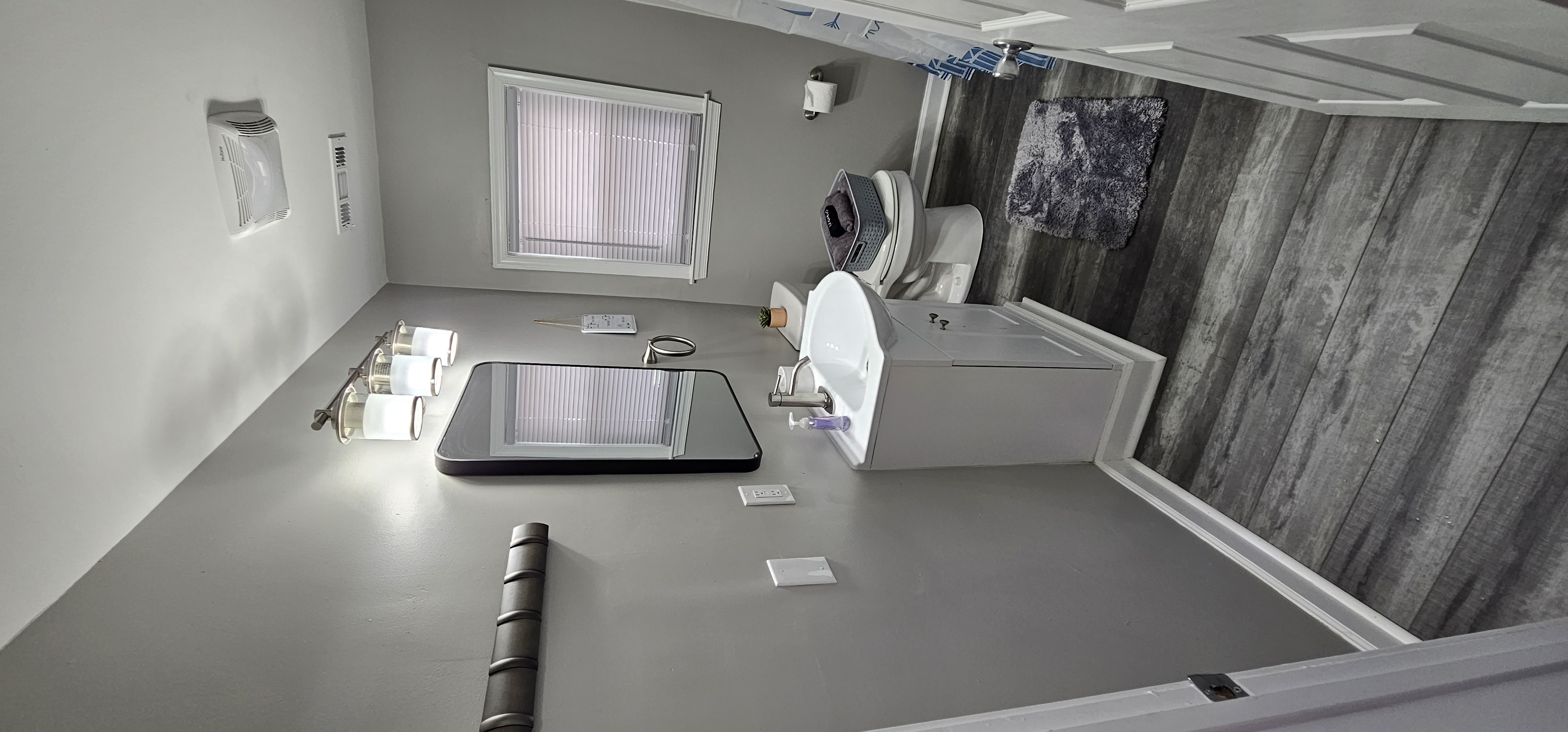 Modern bathroom with a white vanity, mirror, and gray walls