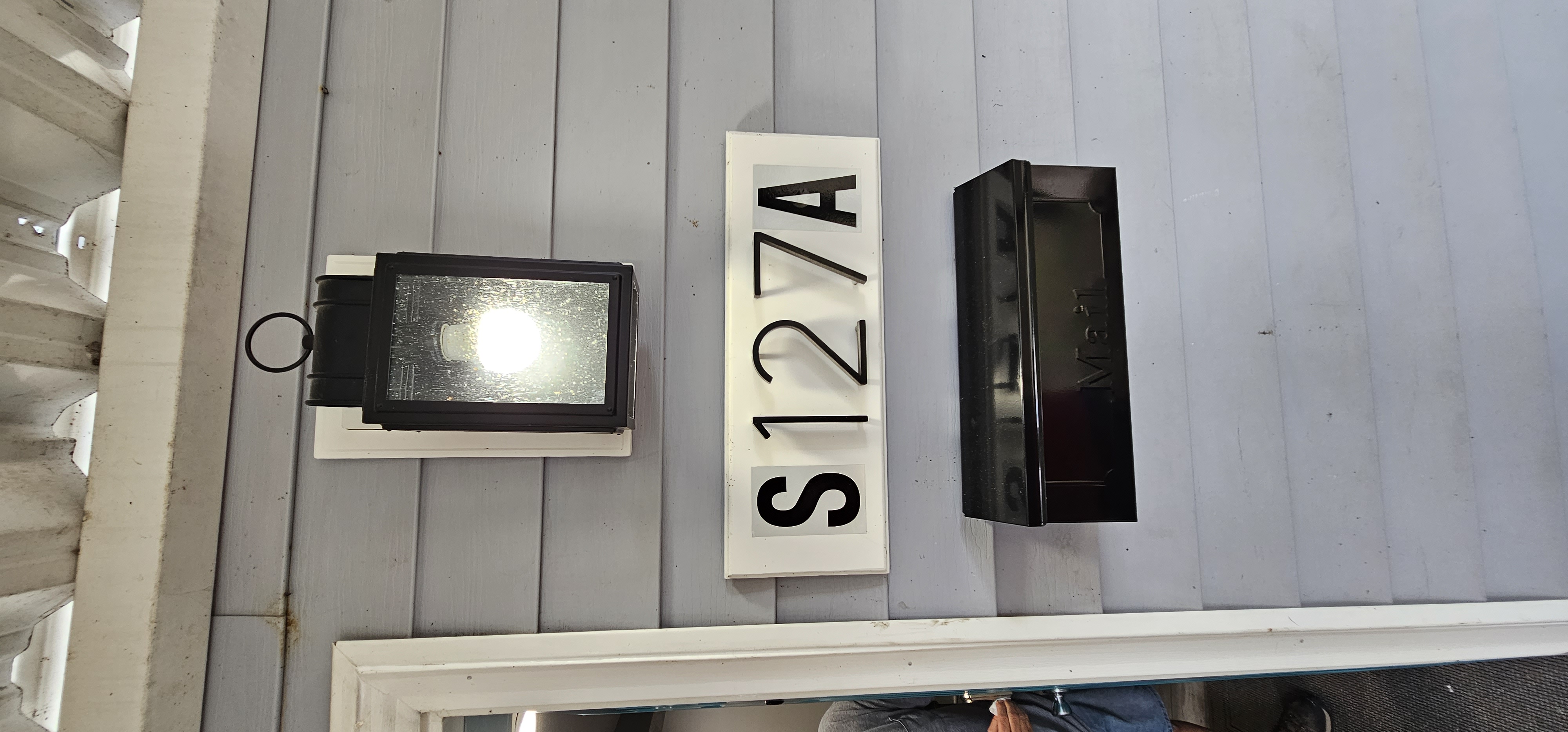 Close-up of the rental home's address sign 'S127A' with a black mailbox mounted below.