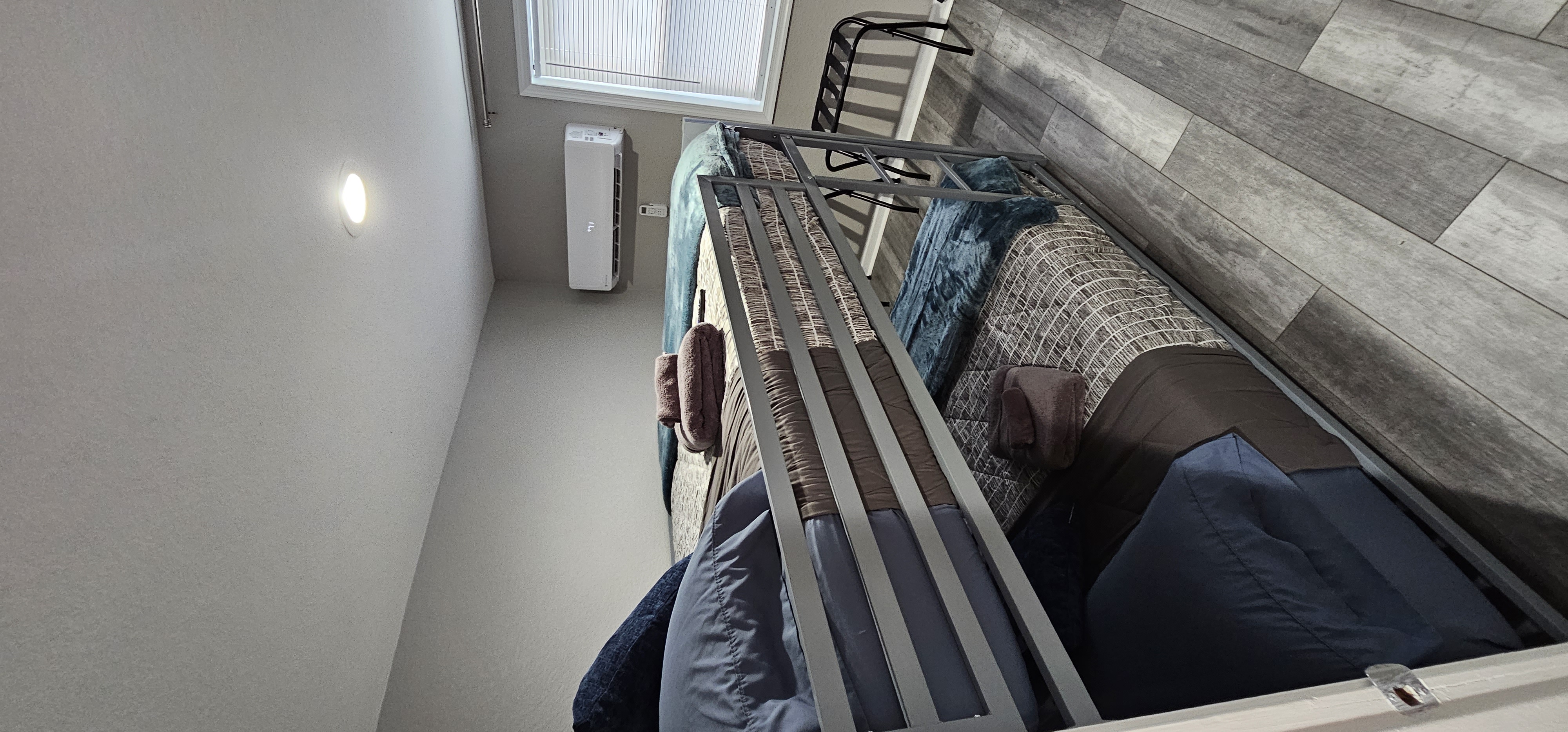 Modern bedroom with bunk beds, a window with curtains, and a mounted TV.