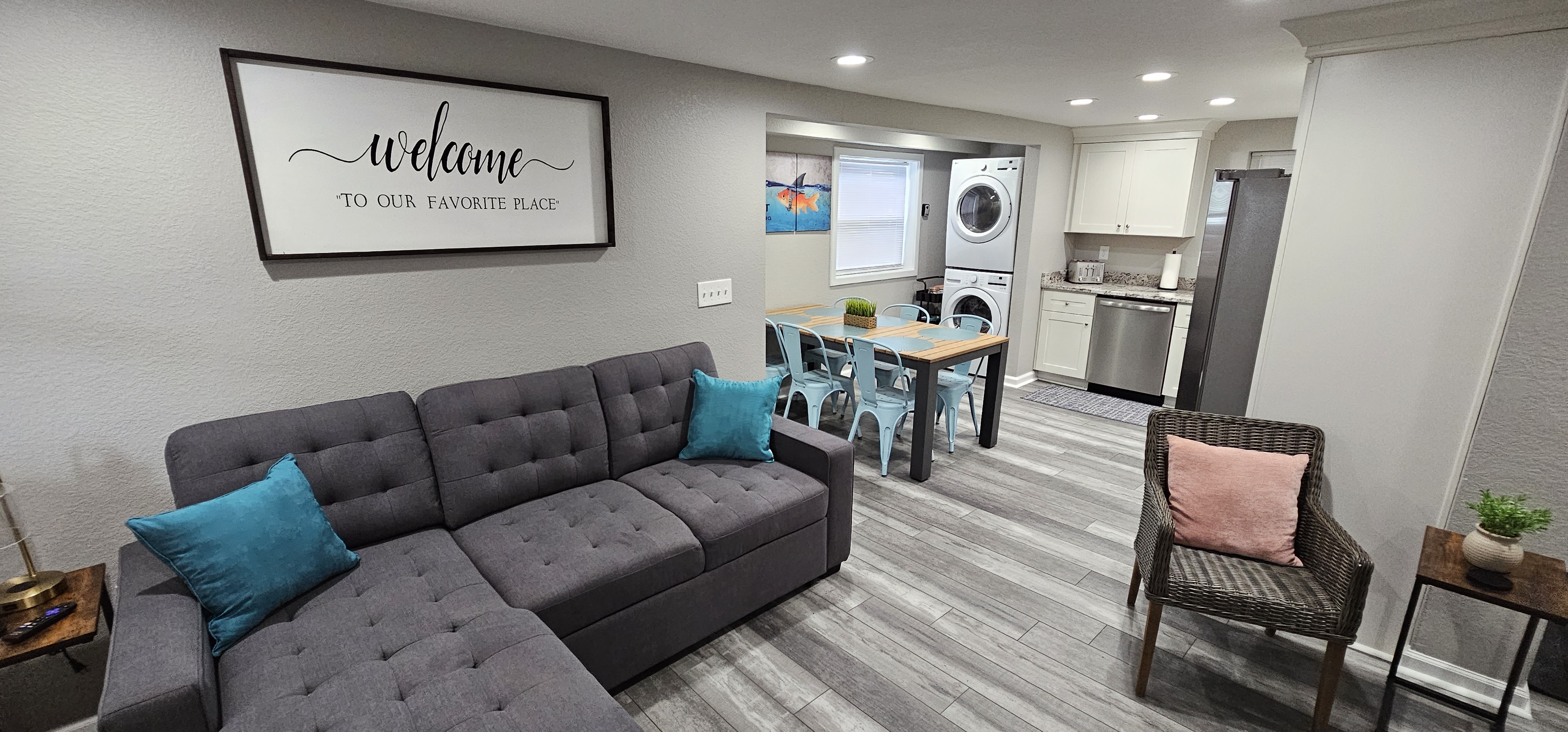 Spacious living room with a sectional sofa, dining area, and kitchen in an open layout.