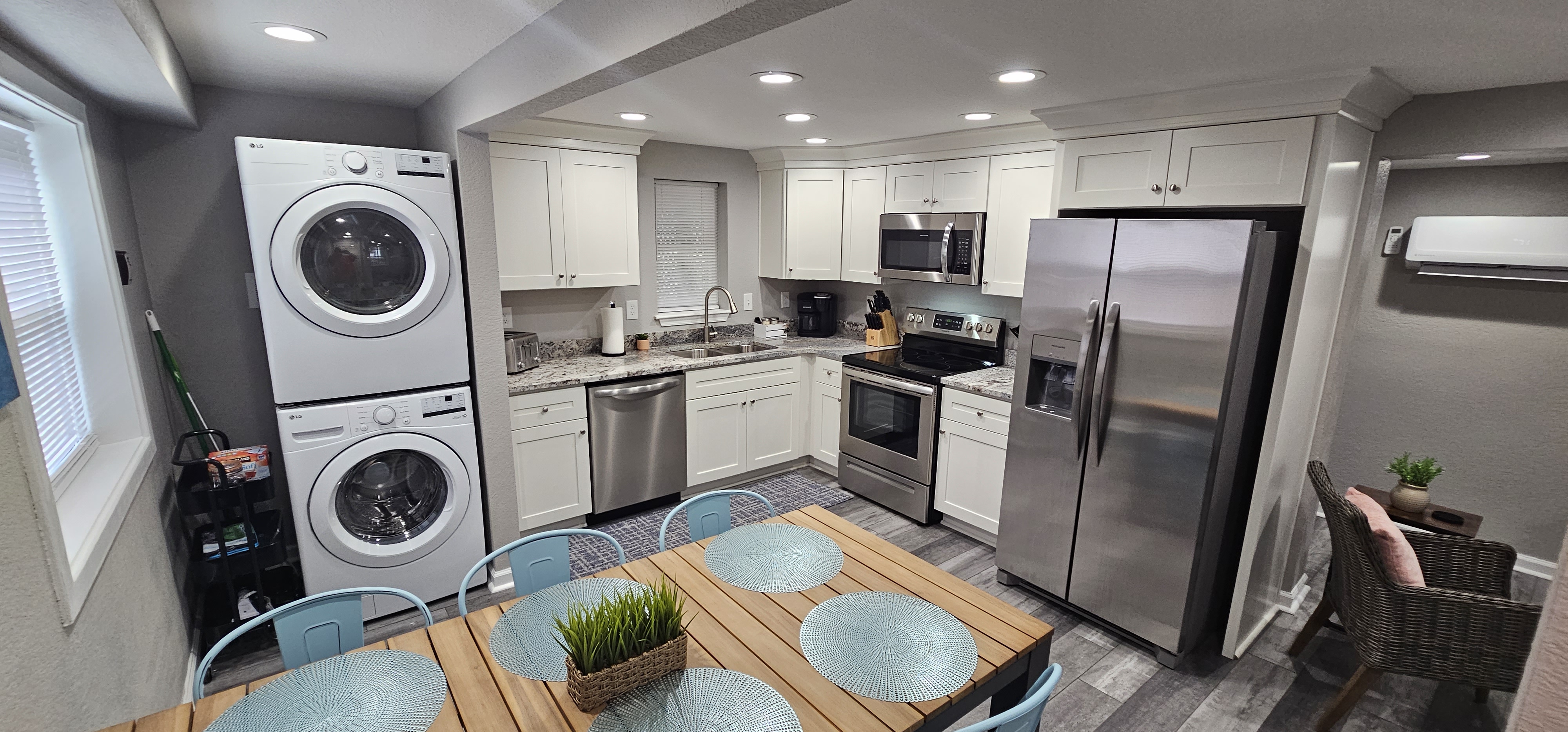 Stylish kitchen with granite countertops, modern appliances, and a dining area with metal chairs.