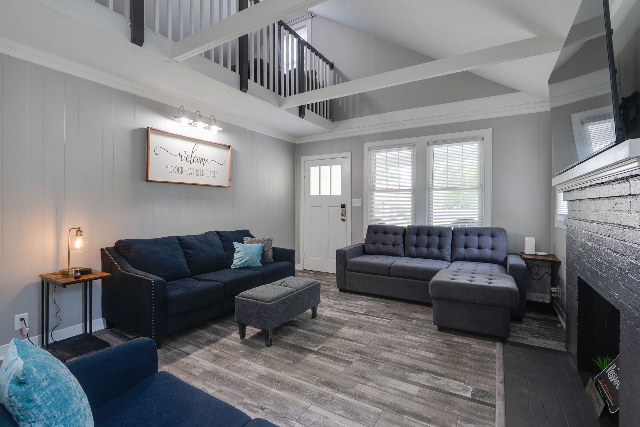 Spacious living area with a loft-style ceiling and inviting furniture.
