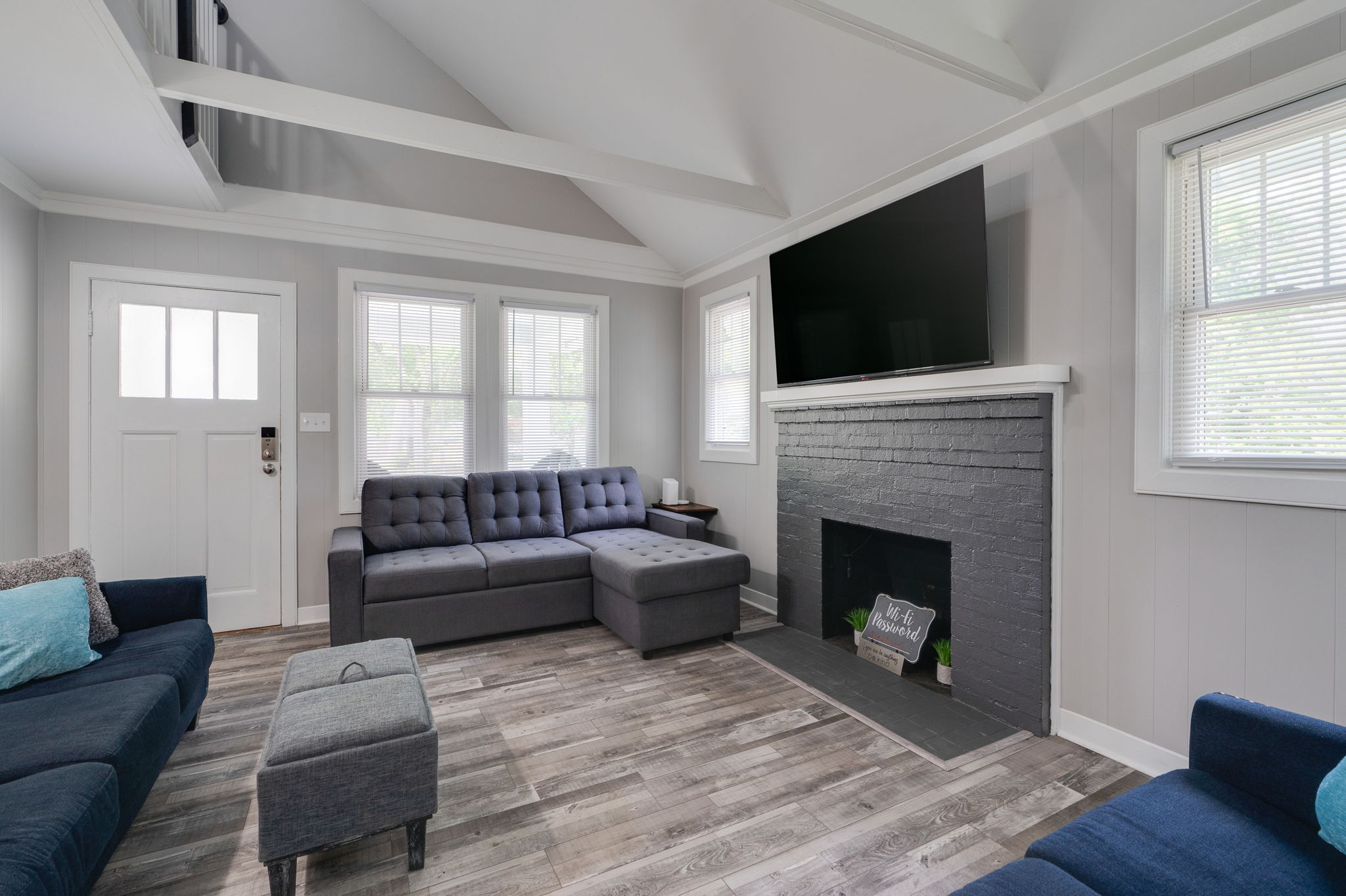 Open-concept living and dining area with a large sectional and fireplace.