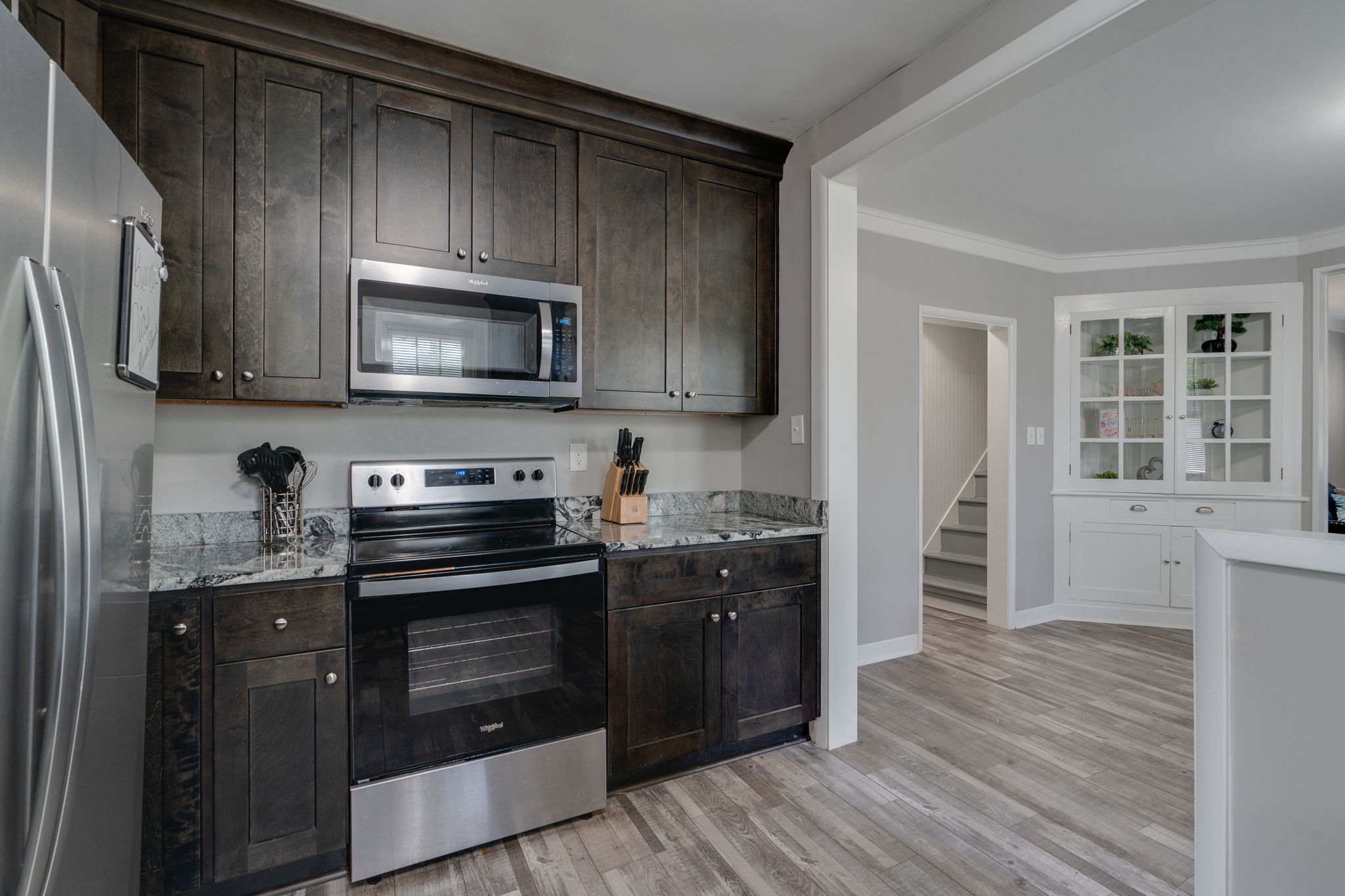 Kitchen view with a built-in microwave, stove, and spacious marble countertops.