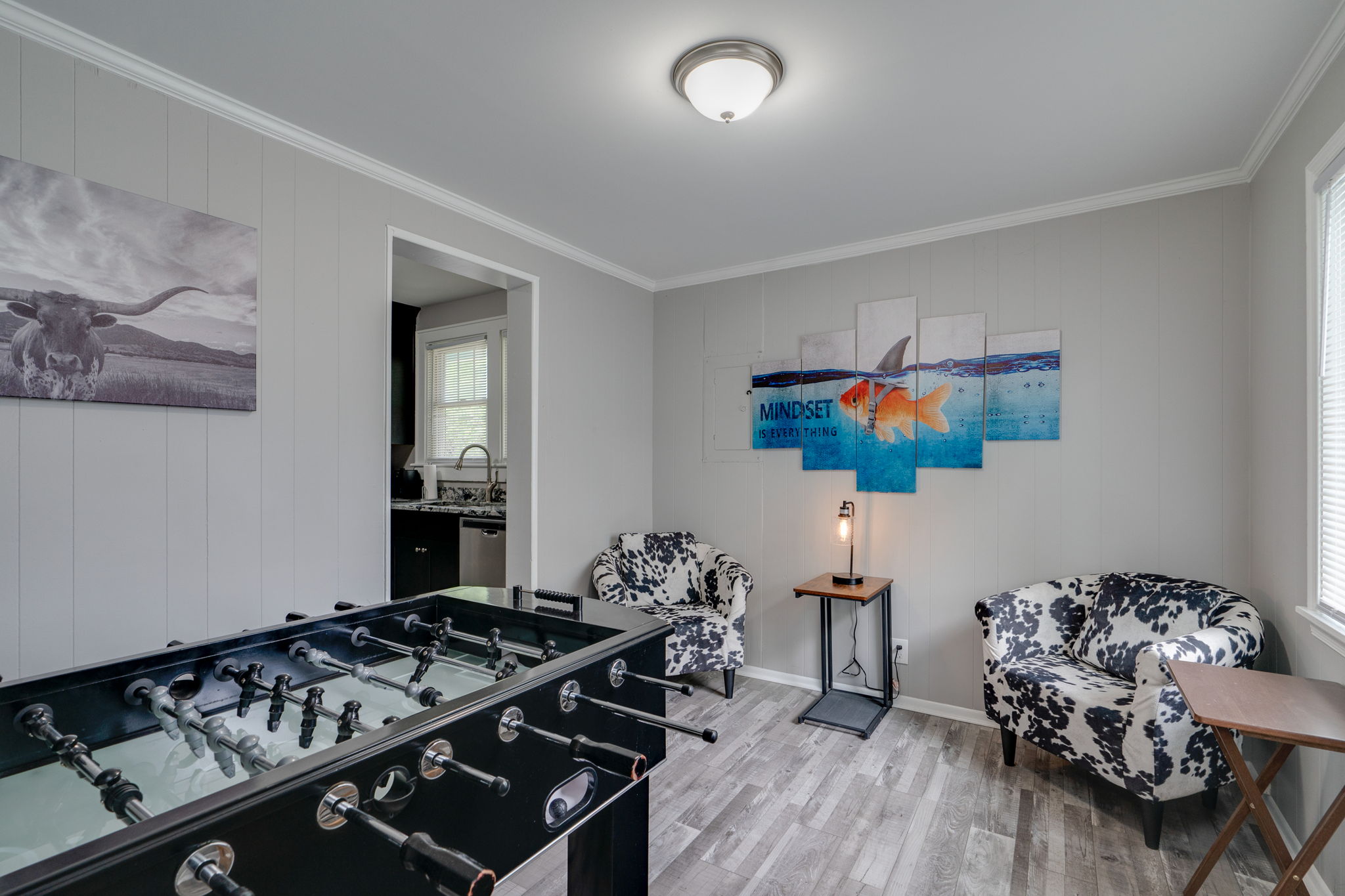 Game room with foosball table, stylish decor, and comfortable seating.