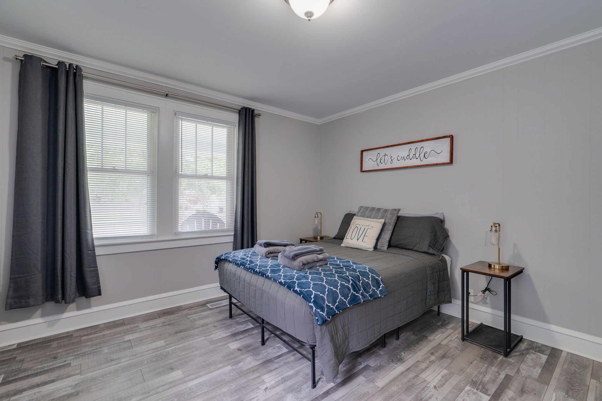 Second bedroom with a stylish decor and a framed sign above the bed.