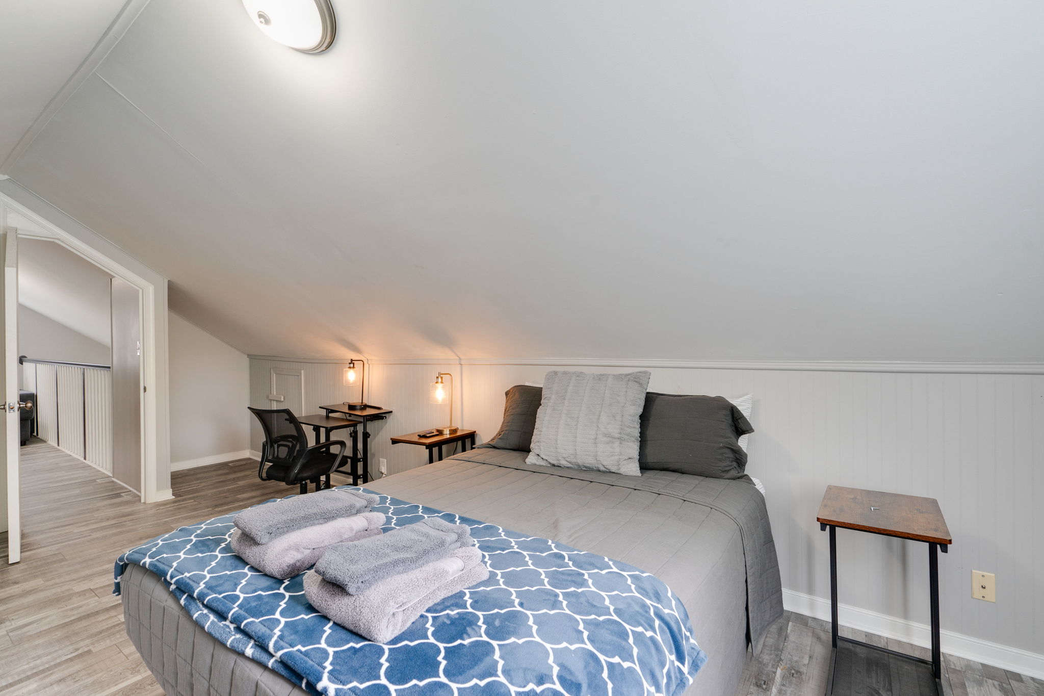 Another angle of the loft bedroom showing a spacious layout and desks.