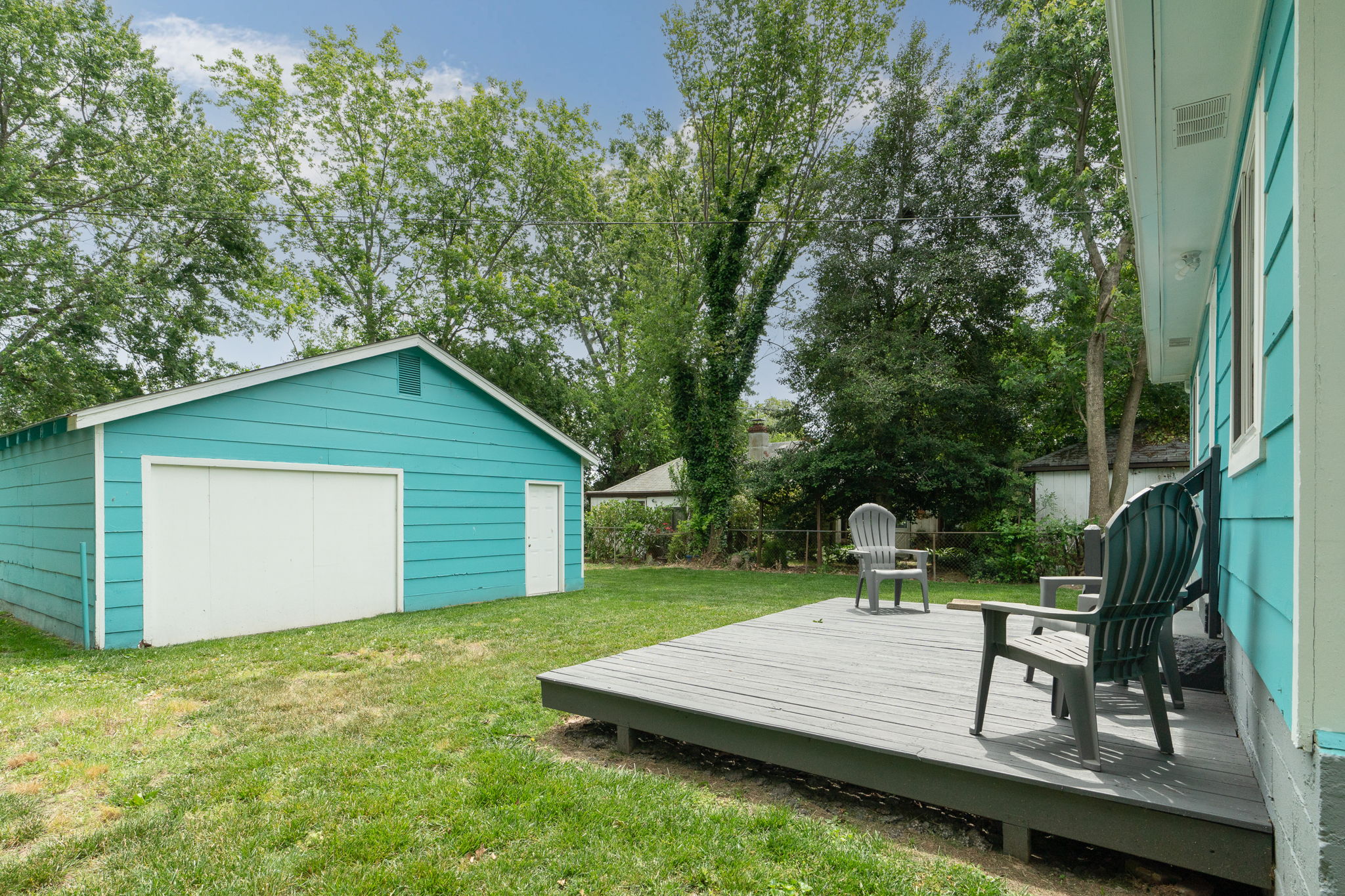 Backyard with a large deck, outdoor seating, and a detached garage.